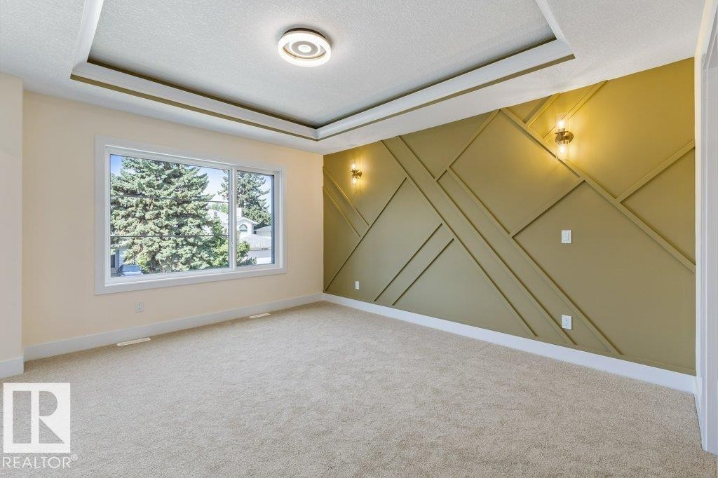 Bedroom 2 - Accent wall featuring geometric paneling and sconce lighting - 10323 79 Street Nw, Edmonton, AB - Indoor Photo Showing Other Room