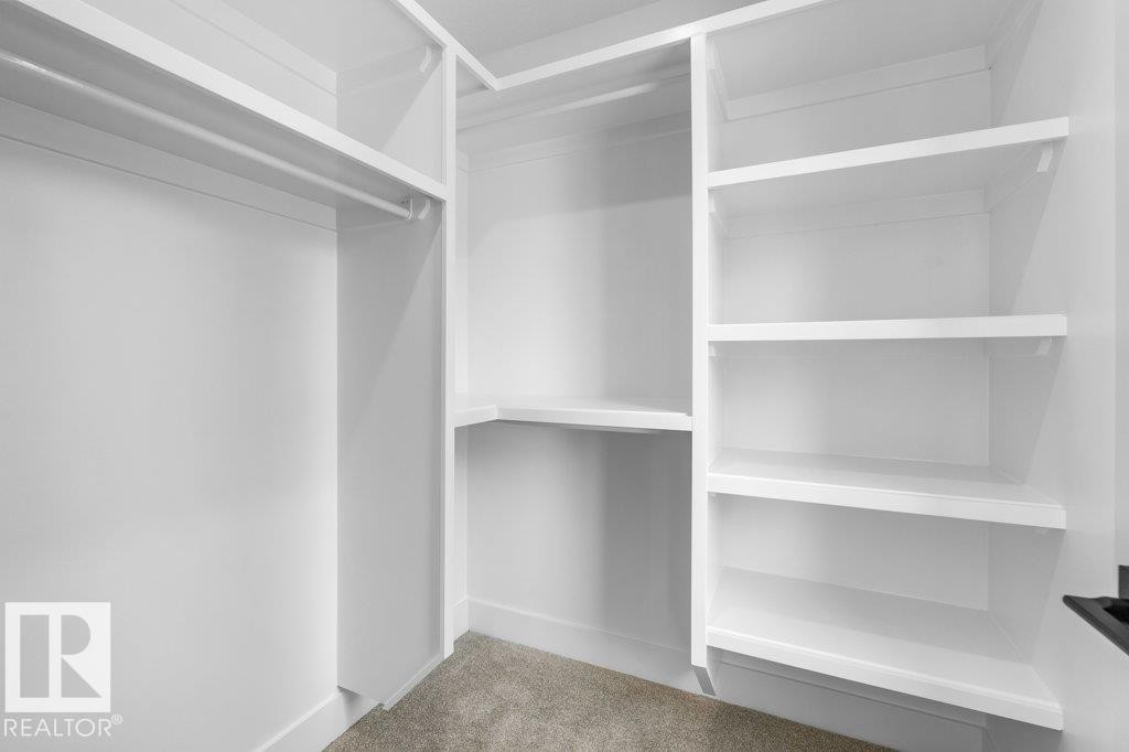 Walk-in closet with white shelving and hanging rods - 10323 79 Street Nw, Edmonton, AB - Indoor With Storage