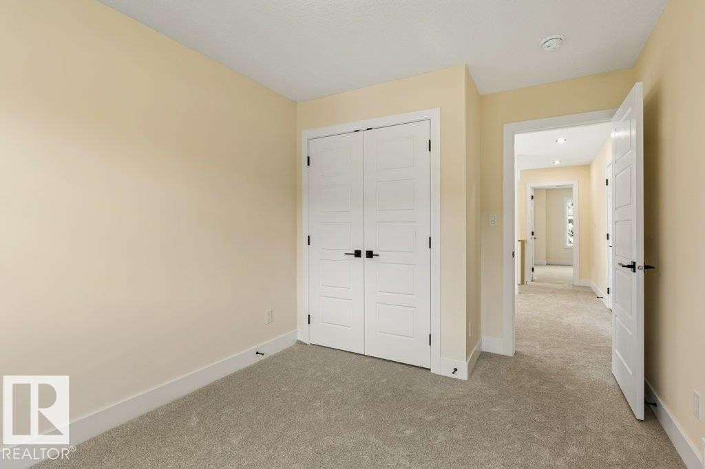 Bedroom 3 - Neutral-toned room featuring light beige walls and light gray carpeting - 10323 79 Street Nw, Edmonton, AB - Indoor Photo Showing Other Room