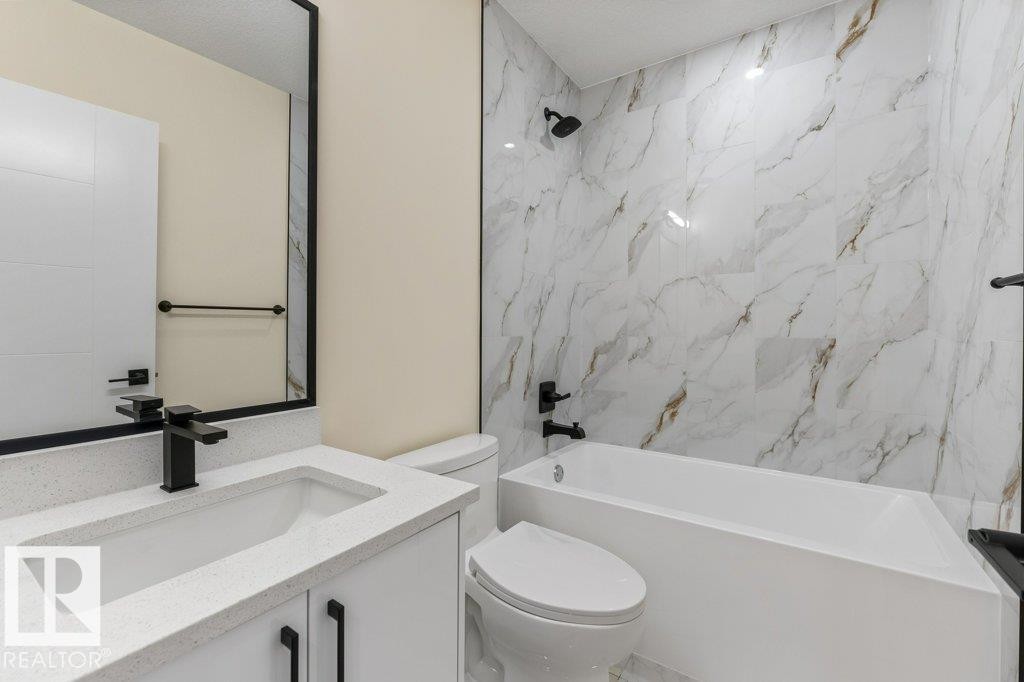 4th Bathroom - 4 Piece - Modern bathroom featuring a white vanity with a quartz countertop, matte black fixtures, a rectangular undermount sink, and a framed mirror - 10323 79 Street Nw, Edmonton, AB - Indoor Photo Showing Bathroom
