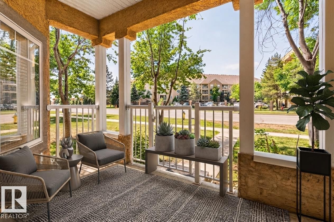 Covered porch with decorative columns, textured wall finish, and white railing - #120 8931 156 St Nw, Edmonton, AB