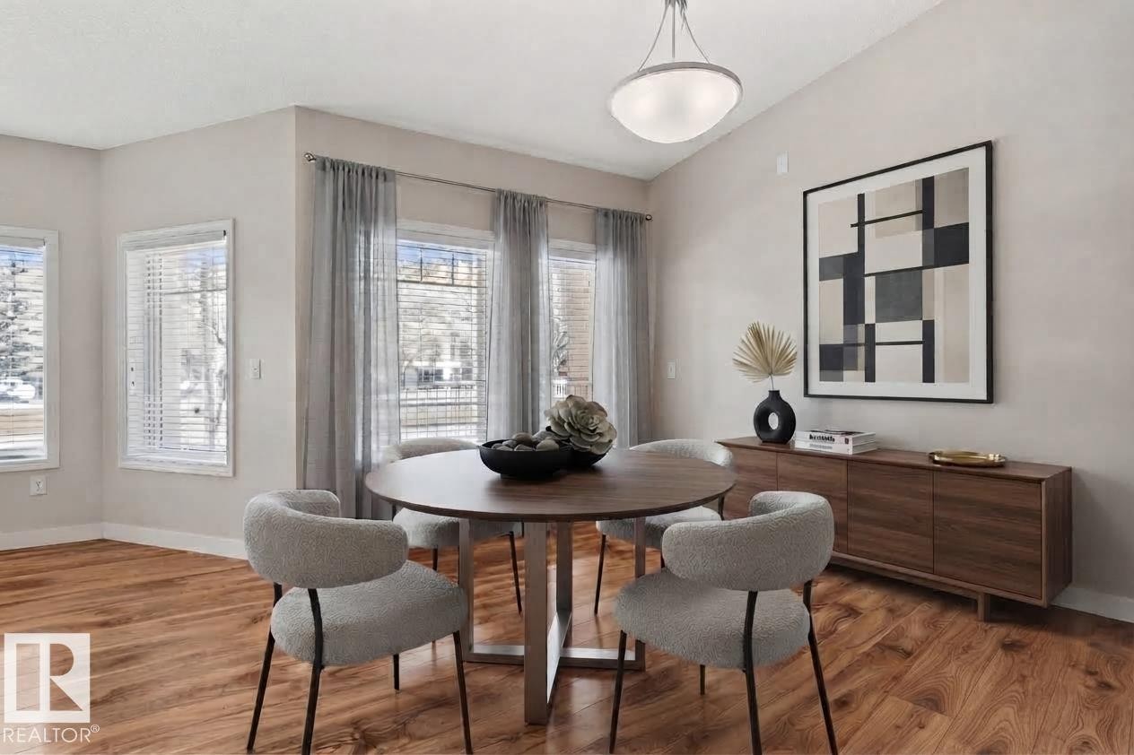Vaulted ceiling with a flush-mount light fixture, wood-finish flooring, and multiple windows - #120 8931 156 St Nw, Edmonton, AB