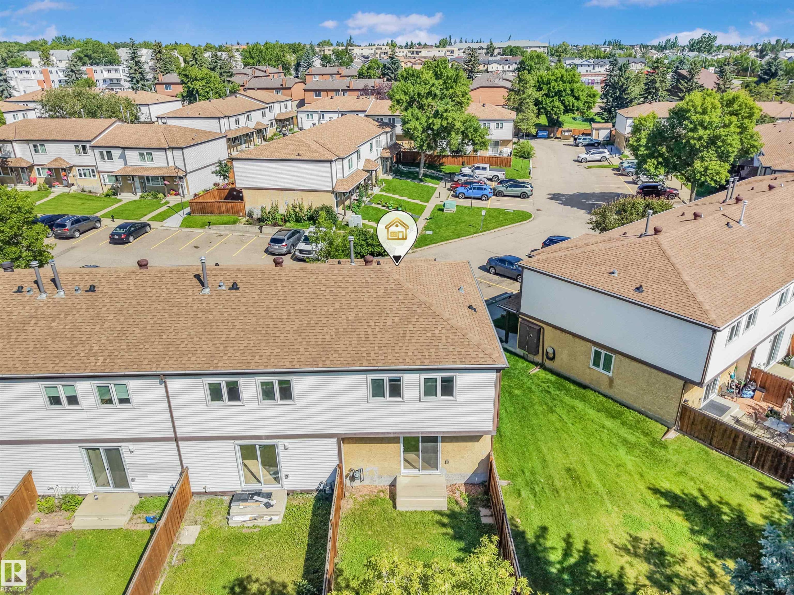 Rear exterior of a townhouse featuring a private fenced yard and sliding patio doors - #39 14511 52 Street Nw, Edmonton, AB - Outdoor