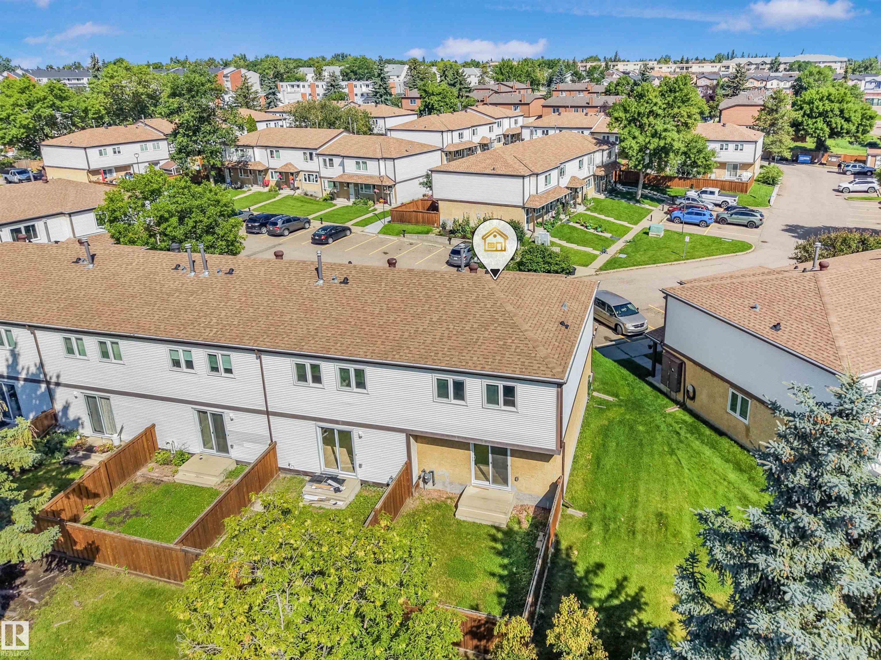 Rear exterior with private fenced yard, concrete patio, and direct access through sliding glass doors - #39 14511 52 Street Nw, Edmonton, AB - Outdoor