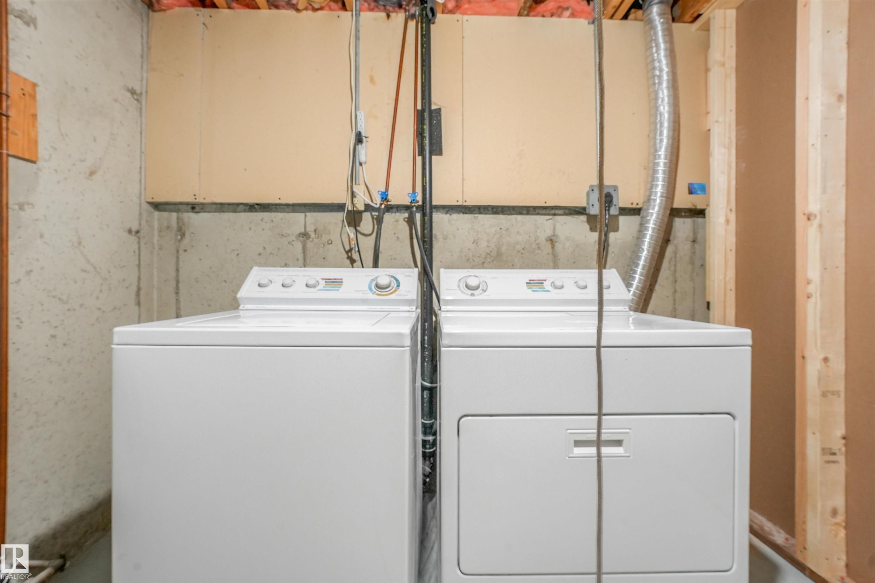 Dedicated laundry area featuring a white top-load washing machine and a white front-load dryer - #39 14511 52 Street Nw, Edmonton, AB - Indoor Photo Showing Laundry Room