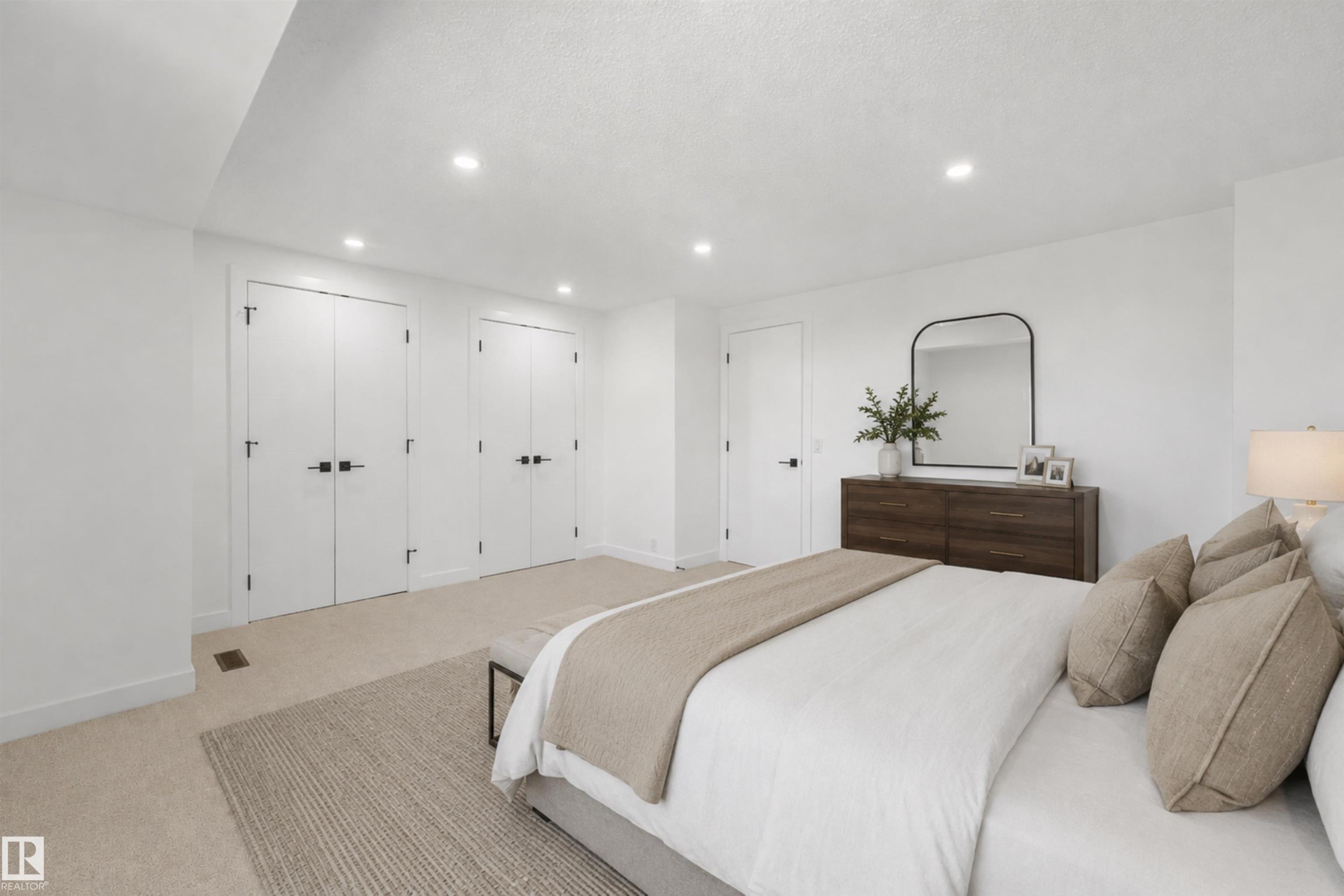 Recessed lighting illuminates the carpeted room, featuring multiple white doors with black hardware - #39 14511 52 Street Nw, Edmonton, AB