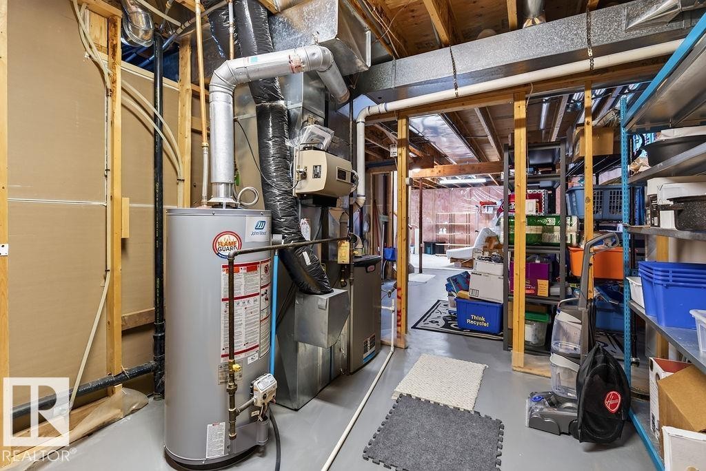 Utility room featuring a water heater, furnace, and exposed ceiling joists - 1046 Jones Crescent Nw, Edmonton, AB - Indoor Photo Showing Bathroom