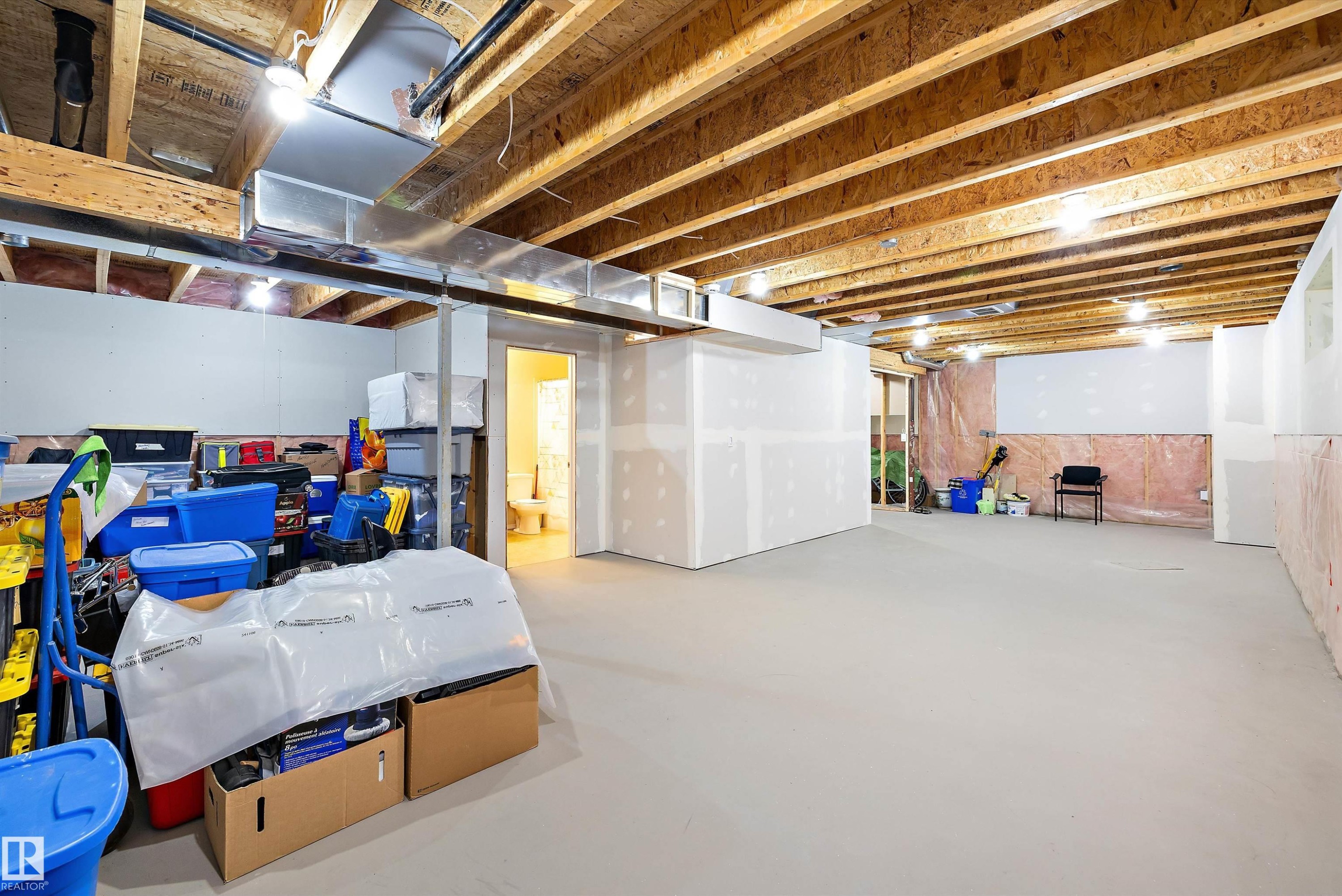 Spacious lower level offering exposed wood joists, overhead lighting, and extensive unfinished wall space for customization - 3344 24 Avenue Nw, Edmonton, AB - Indoor Photo Showing Basement