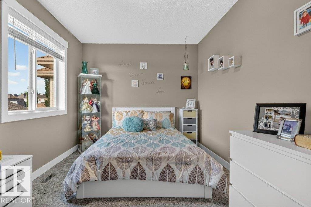 Neutral-toned room featuring a large window with white blinds, light gray wall paint, and gray carpet flooring - 5322 Terwillegar Boulevard Nw, Edmonton, AB - Indoor Photo Showing Bedroom