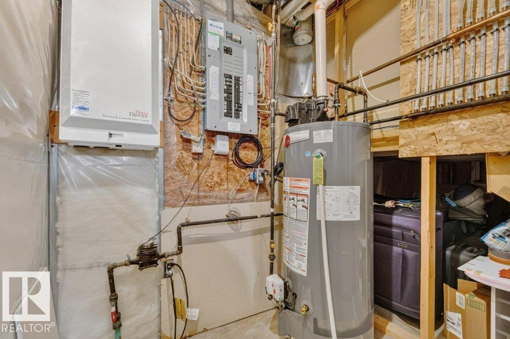 Dedicated utility space featuring a water heater, electrical panel, and visible plumbing and wiring - 5322 Terwillegar Boulevard Nw, Edmonton, AB - Indoor Photo Showing Basement