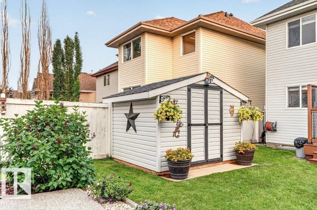 Backyard featuring a shed with double doors, a gabled roof, and white siding - 5322 Terwillegar Boulevard Nw, Edmonton, AB - Outdoor With Exterior