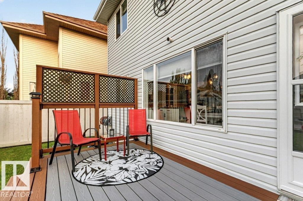 Multi-level deck featuring composite decking, wood-finish railing with black balusters, and privacy lattice - 5322 Terwillegar Boulevard Nw, Edmonton, AB - Outdoor With Deck Patio Veranda With Exterior