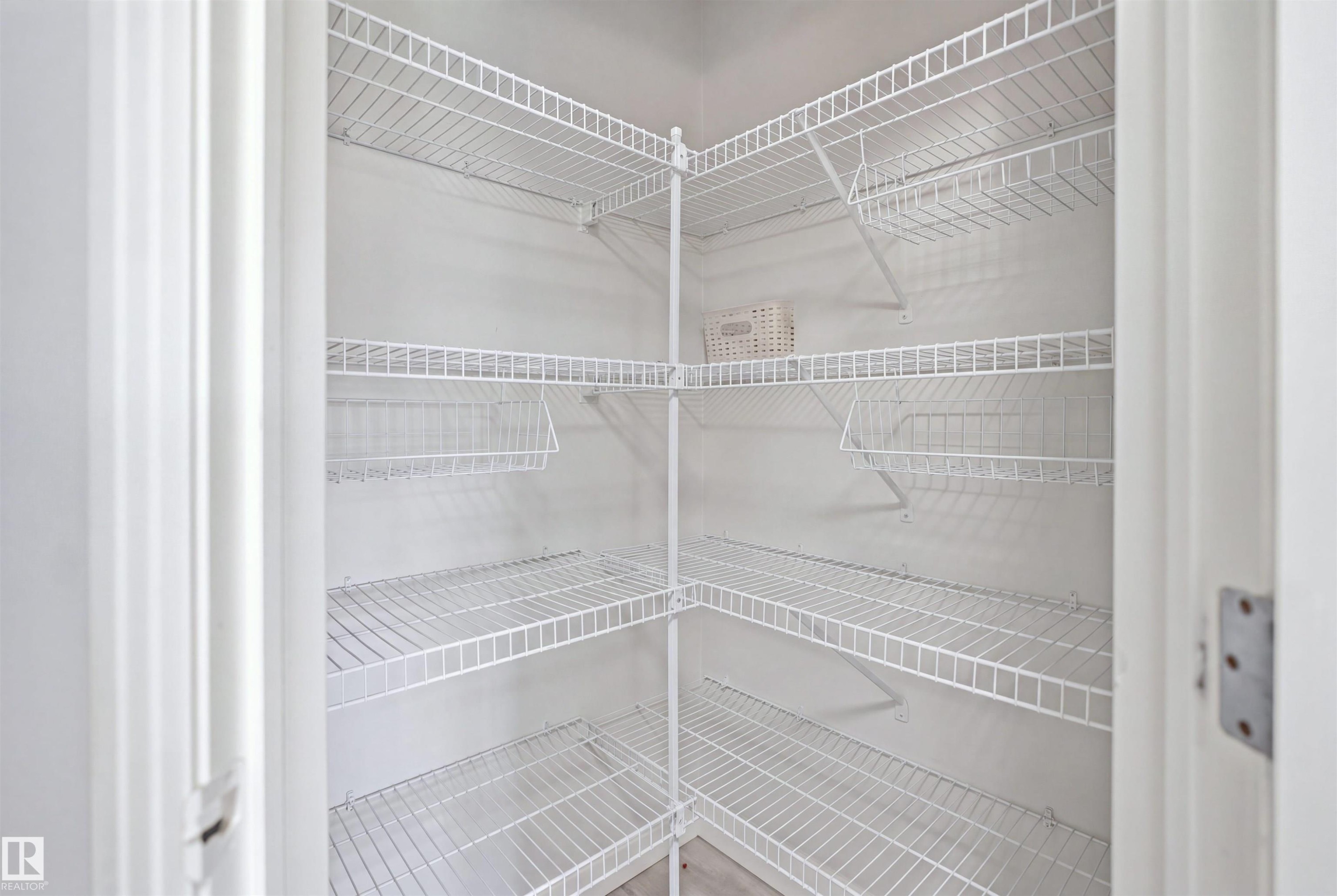 Corner pantry featuring white wire shelving, multiple storage levels, and integrated wire baskets - 714 87 Street Sw, Edmonton, AB - Indoor With Storage