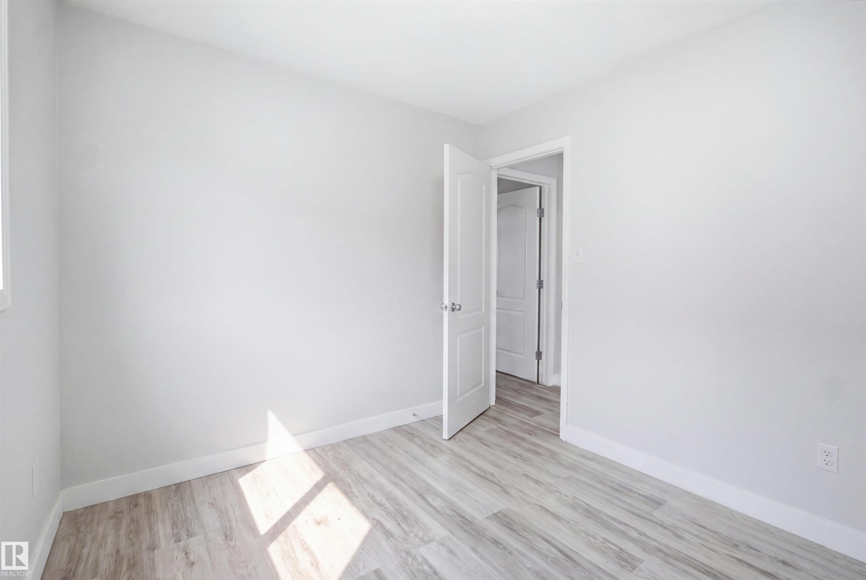 Room featuring light wood-finish flooring, white walls, and white baseboards - 714 87 Street Sw, Edmonton, AB - Indoor Photo Showing Other Room