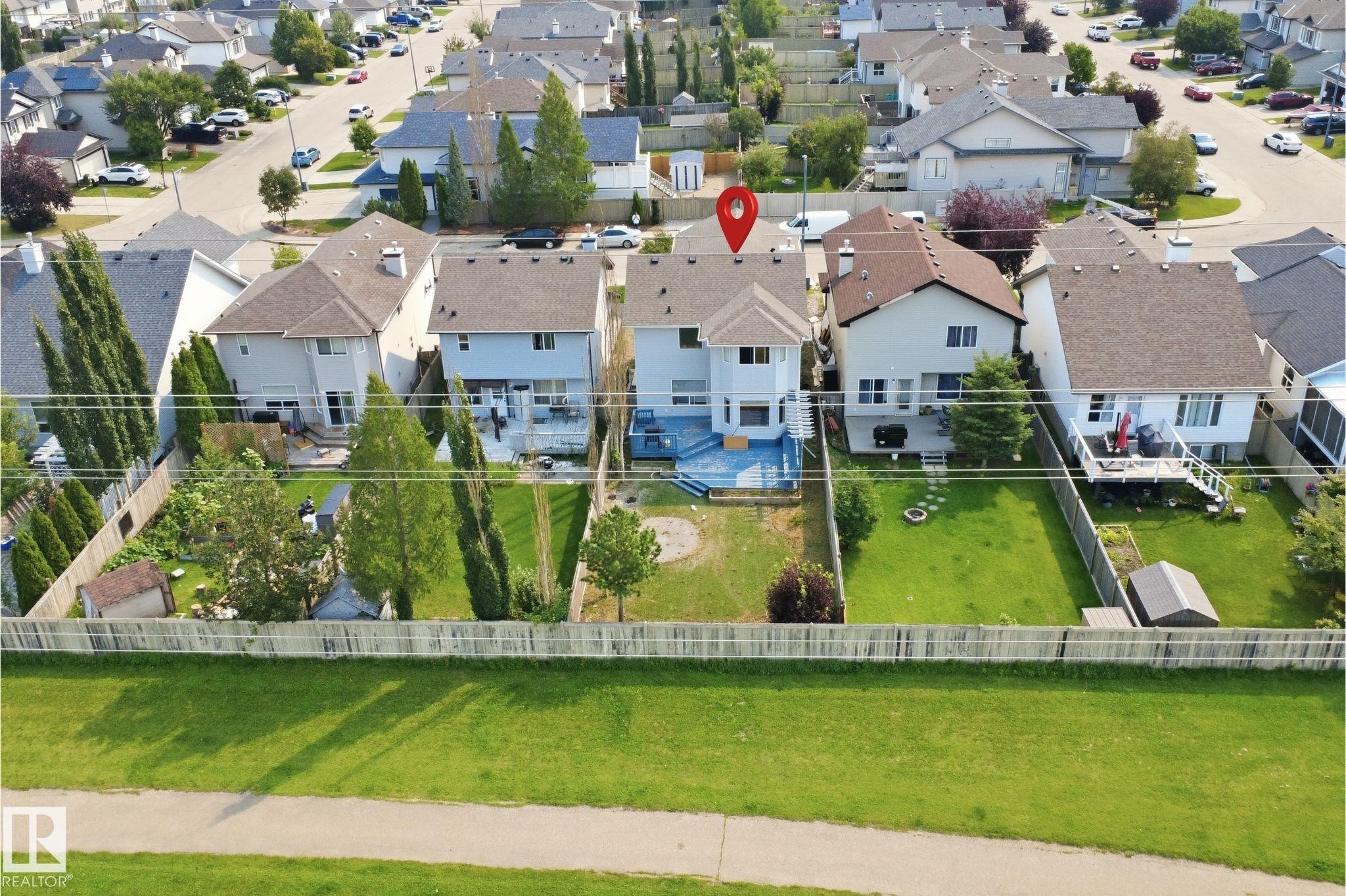 Two-story residence featuring a blue deck, private fenced yard with mature trees, and an exterior storage shed - 714 87 Street Sw, Edmonton, AB - Outdoor With View