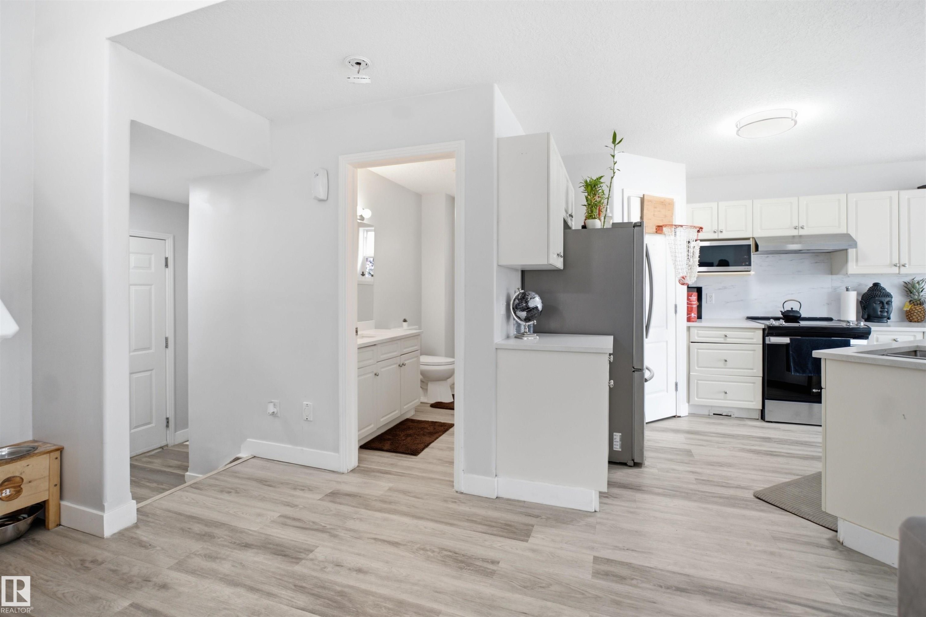 Open-concept living space with wood-finish flooring throughout - 714 87 Street Sw, Edmonton, AB - Indoor Photo Showing Kitchen