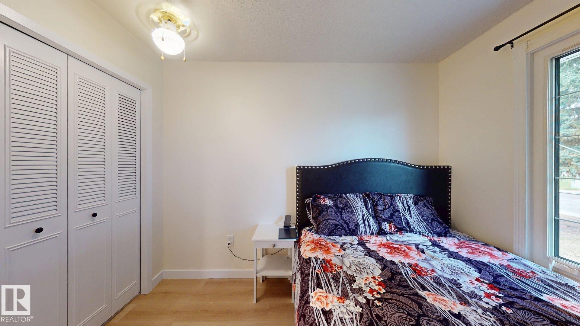 Bedroom featuring light wood-finish flooring and a ceiling-mounted fan - 12812 45 Street Nw, Edmonton, AB - Indoor Photo Showing Bedroom