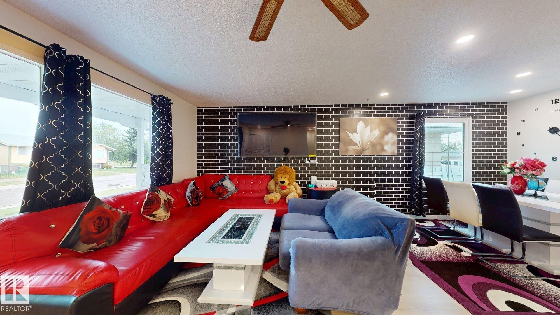 Expansive living area featuring a large picture window, recessed lighting, and a textured accent wall - 12812 45 Street Nw, Edmonton, AB - Indoor