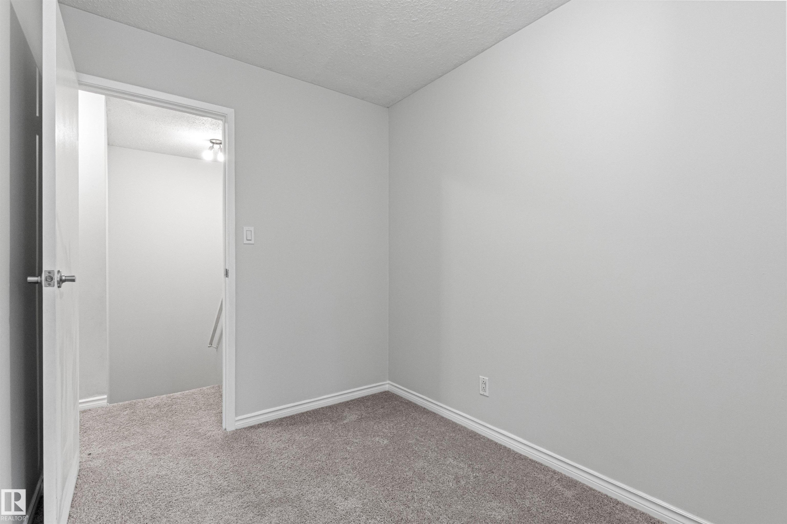 Gray carpeting with white baseboards, light-toned walls, and a white ceiling - #9 14230 80 St Nw, Edmonton, AB - Indoor Photo Showing Other Room