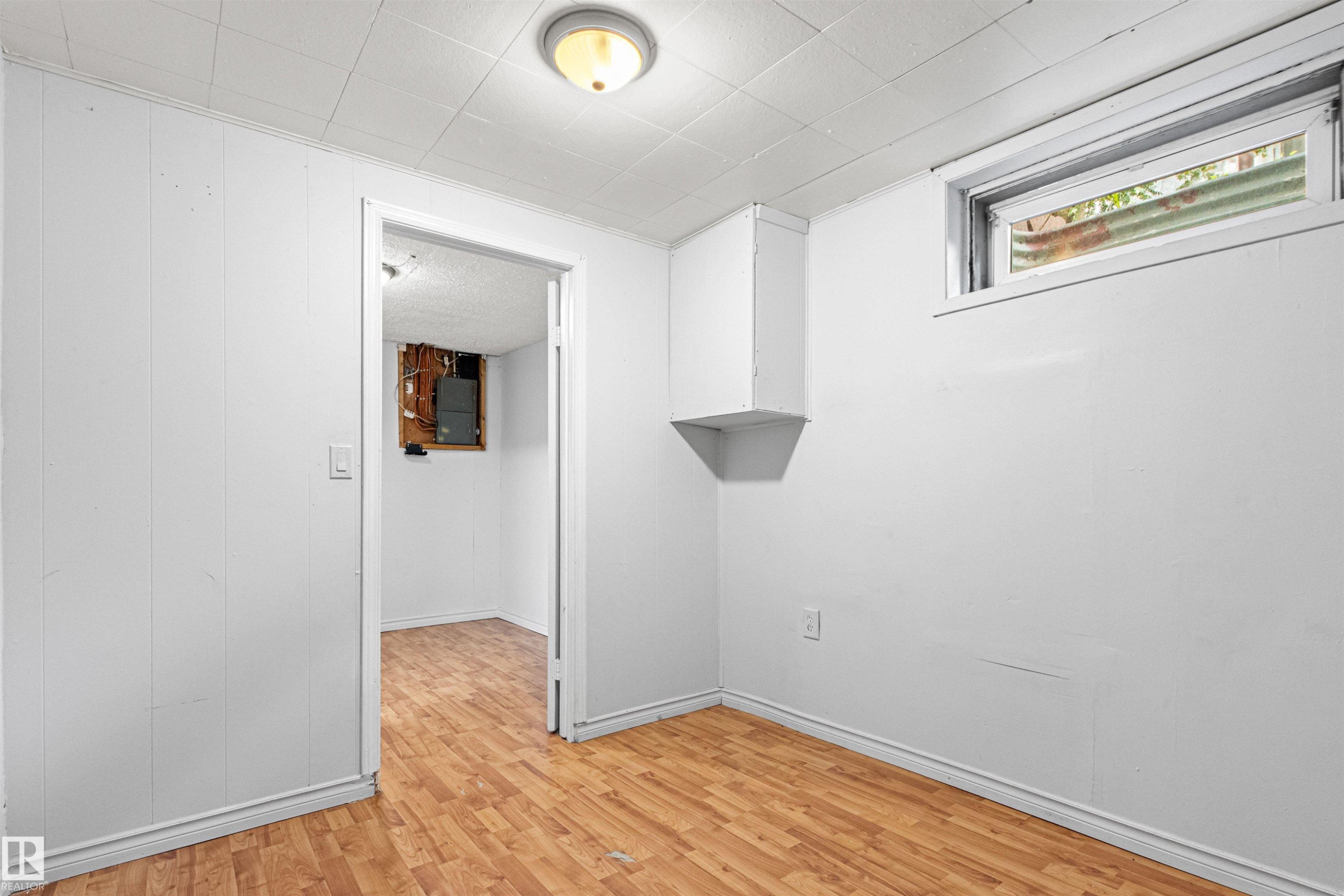 Wood-finish flooring with white wall paneling - #9 14230 80 St Nw, Edmonton, AB - Indoor Photo Showing Other Room