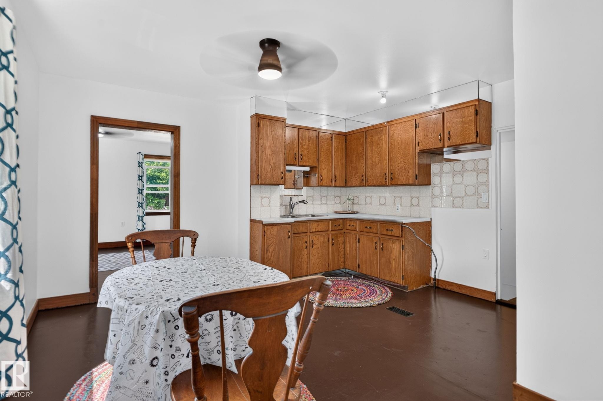 Kitchen featuring wood cabinetry, white countertops, and a tile backsplash - 9921 109 Street, Fort Saskatchewan, AB - Indoor