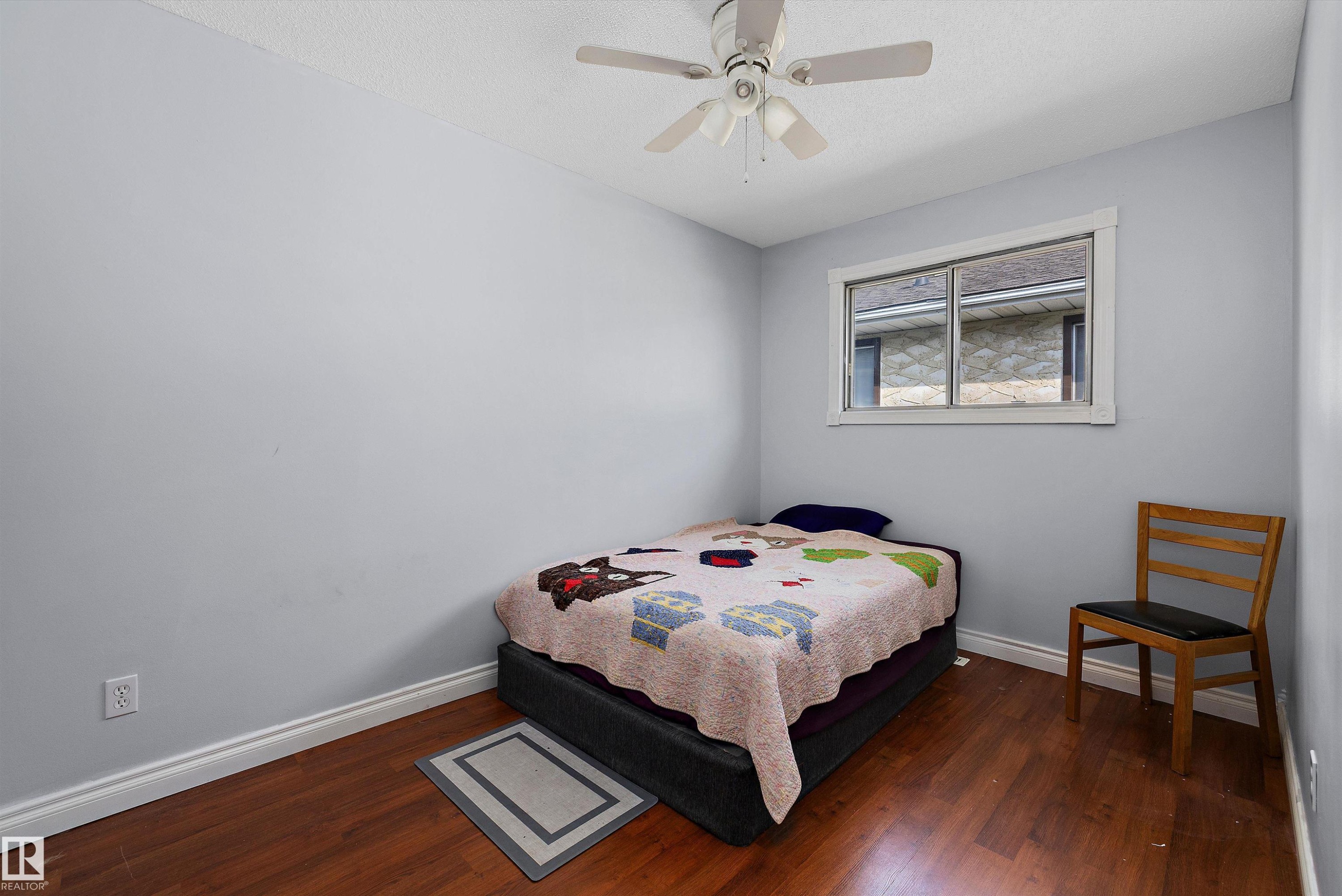 Wood-finish flooring, light gray walls, white window trim, and a ceiling fan with integrated lighting - 3511 73 Street Nw, Edmonton, AB - Indoor Photo Showing Bedroom