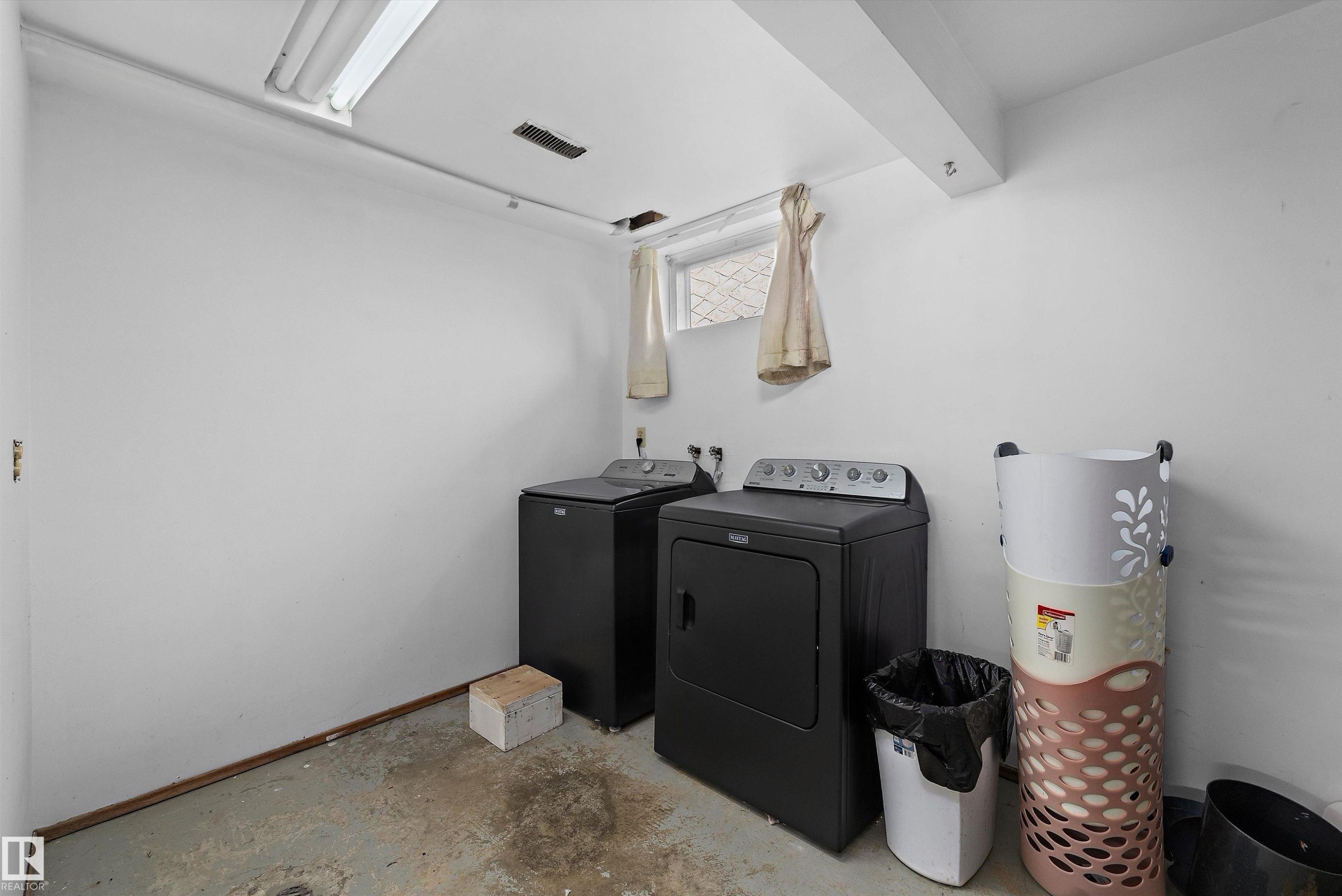 Laundry area featuring a washer and dryer, exposed ceiling beam, fluorescent lighting, and a small window - 3511 73 Street Nw, Edmonton, AB - Indoor Photo Showing Laundry Room
