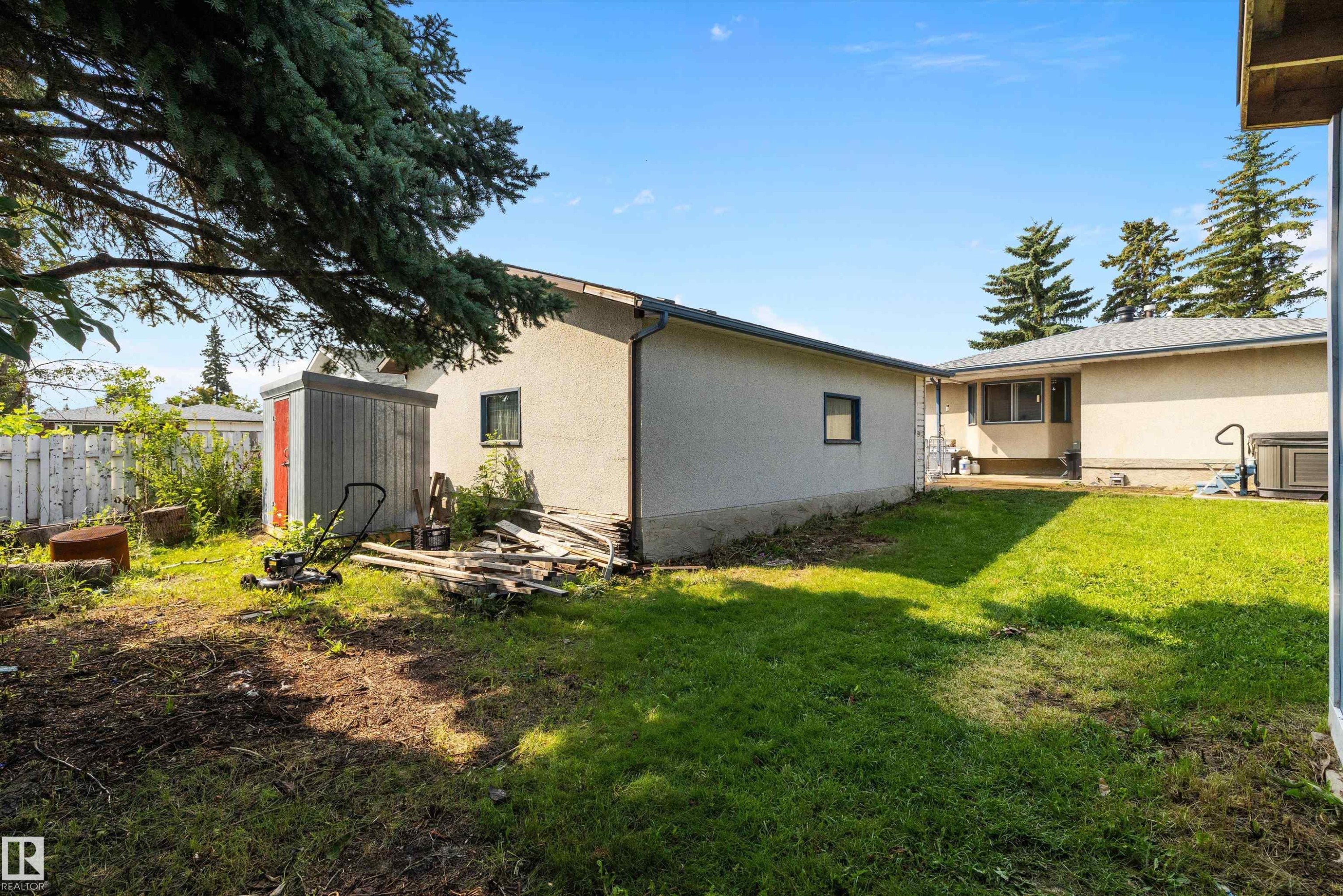 Expansive backyard featuring mature evergreen trees, manicured lawn, and established landscaping - 3511 73 Street Nw, Edmonton, AB - Outdoor