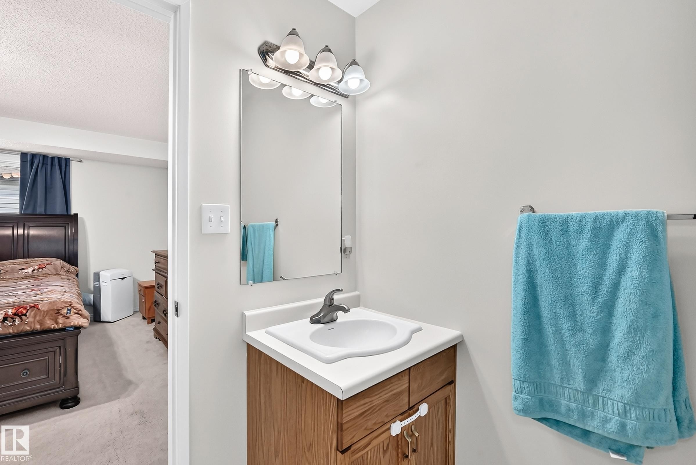 Bathroom vanity with a basin sink, chrome faucet, and integrated mirror - 2404 37 Street Nw, Edmonton, AB - Indoor Photo Showing Bathroom