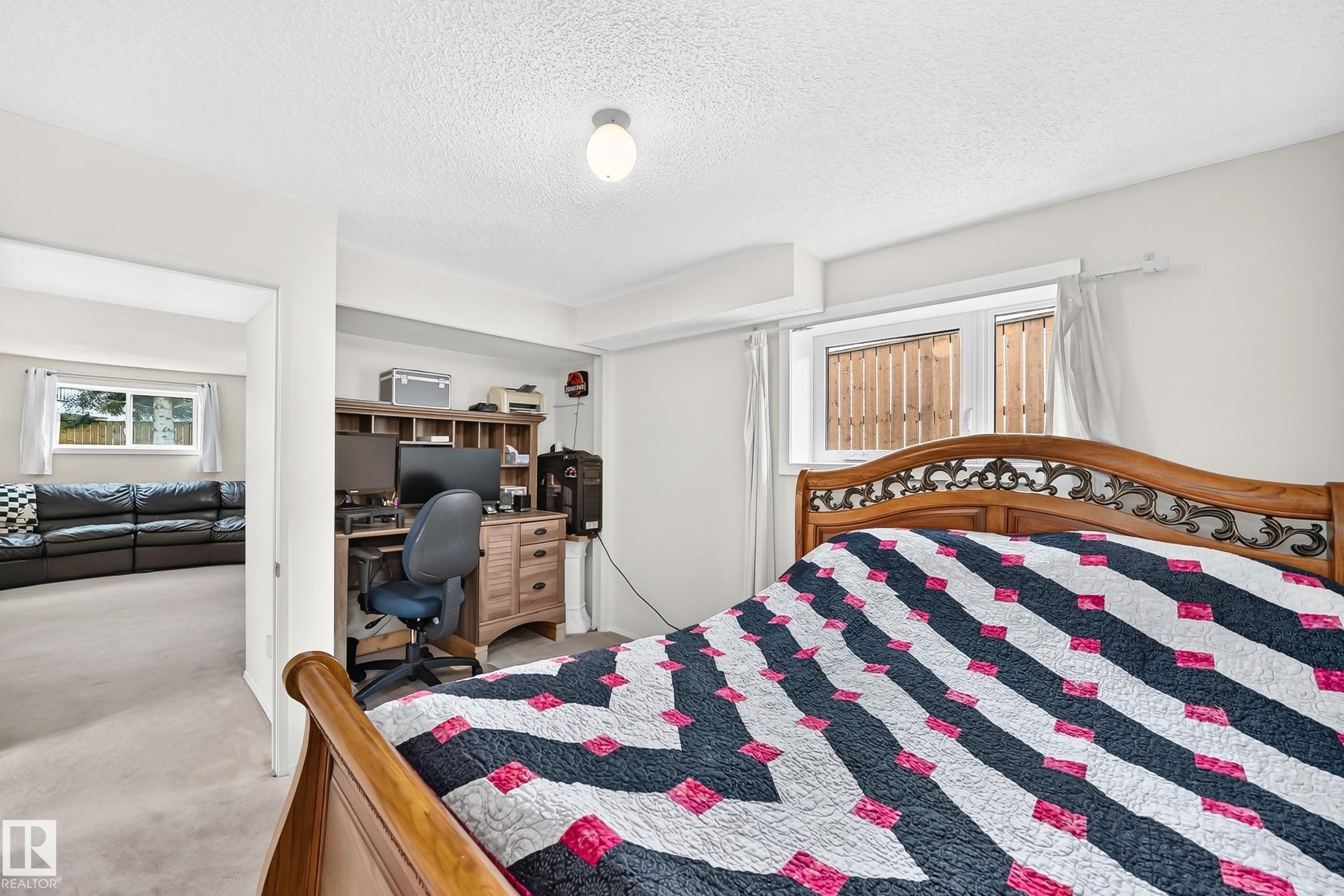 Recessed ceiling light fixture, window with white trim, wood-finish desk with storage, built-in shelving, and carpeted flooring - 2404 37 Street Nw, Edmonton, AB - Indoor Photo Showing Bedroom