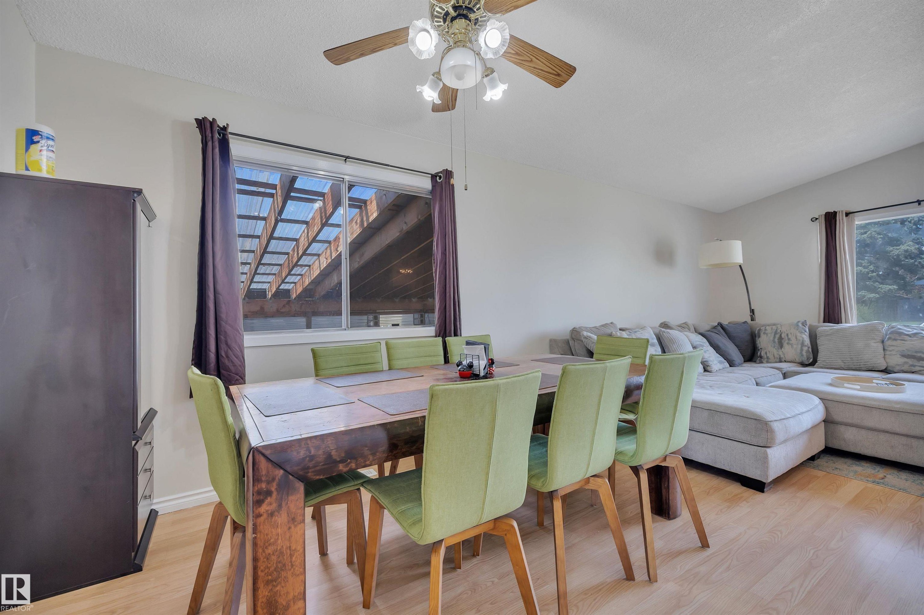 Dining area featuring light wood-finish flooring, a ceiling fan with light fixture, and a window providing natural light - 5411 44 Ave, Wetaskiwin, AB - Indoor Photo Showing Other Room