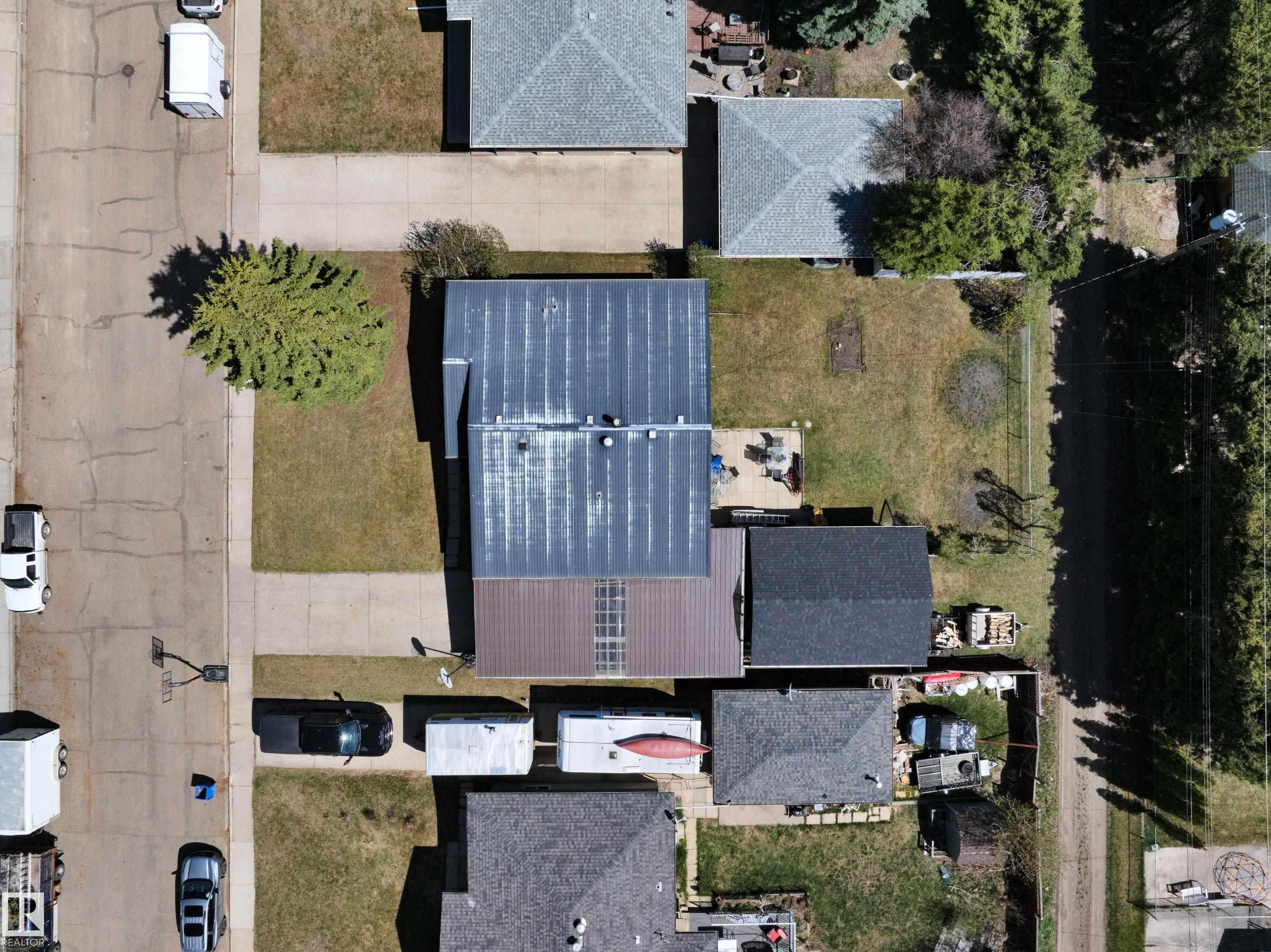 Property featuring a central residence with a metal roof and an attached auxiliary structure with an asphalt shingle roof - 5411 44 Ave, Wetaskiwin, AB - Outdoor