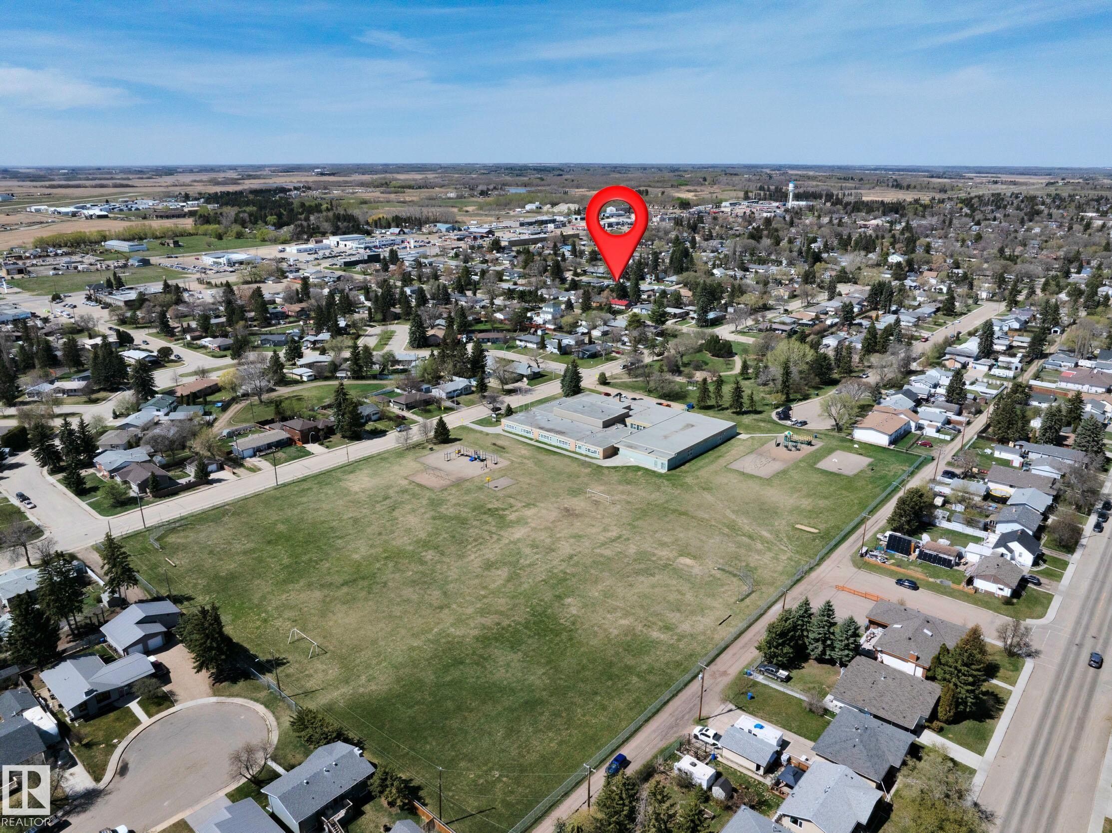 Aerial perspective showcasing the residential neighborhood with a large green field and a school building - 5411 44 Ave, Wetaskiwin, AB - Outdoor With View