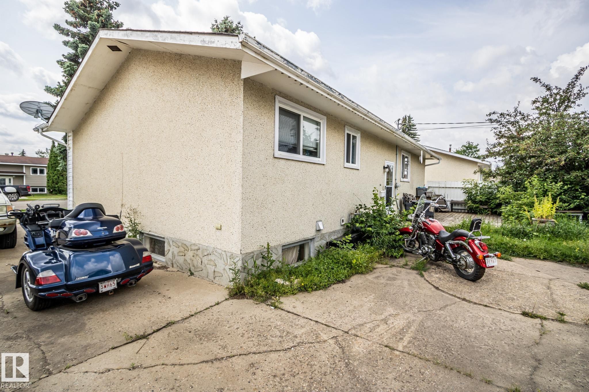 Stucco exterior with stone veneer foundation - 4322 49 Ave, St. Paul Town, AB - Outdoor With Exterior