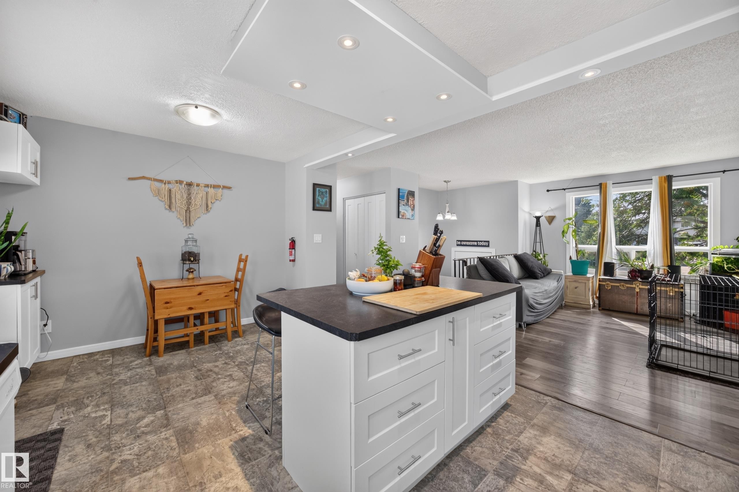 Kitchen island with built-in storage, contrasting dark countertop, recessed lighting, and wood-finish flooring - 156 Clareview Road Nw, Edmonton, AB - Indoor