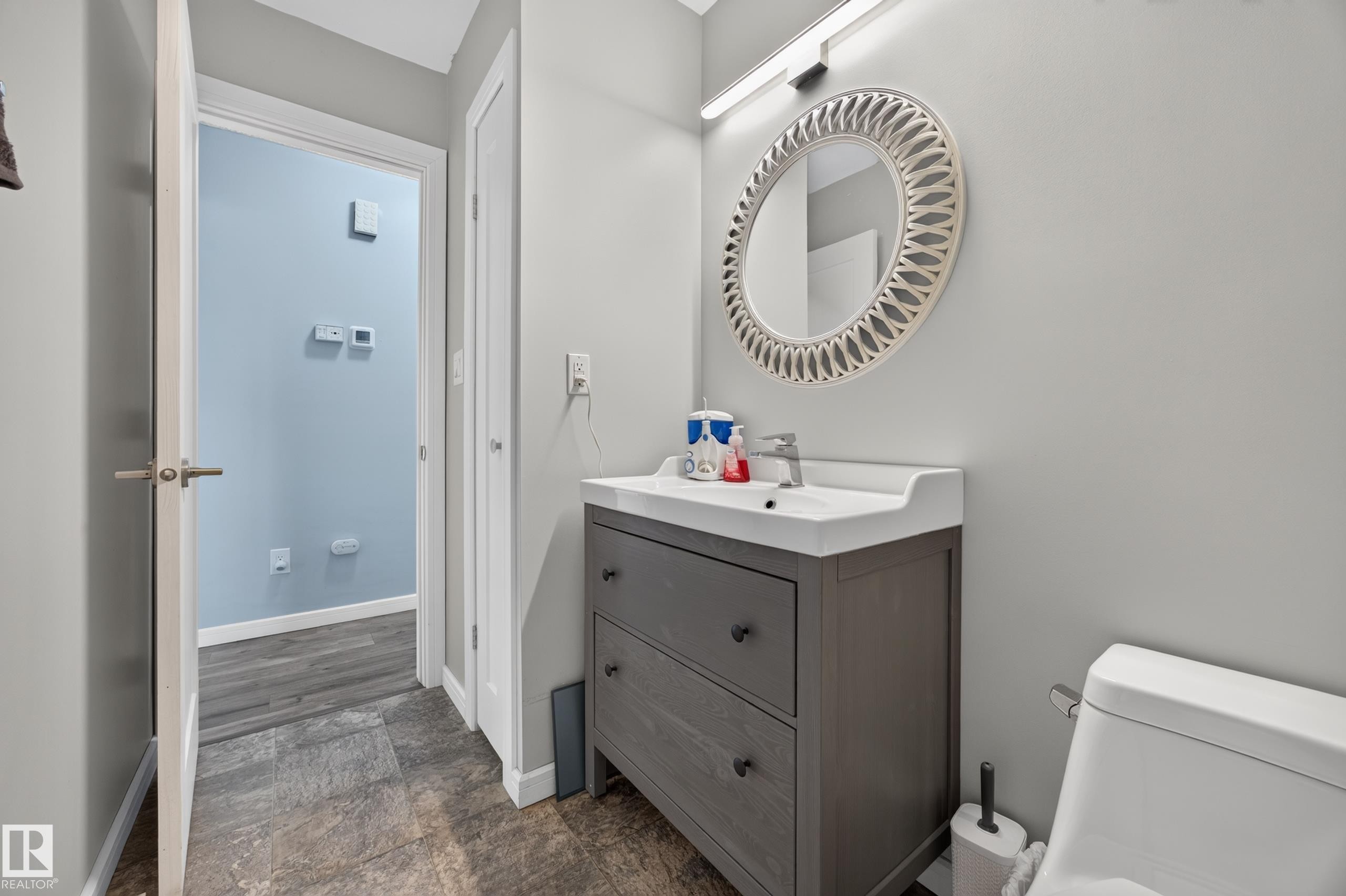 Modern vanity with integrated sink, brushed nickel faucet, and wood-finish flooring - 156 Clareview Road Nw, Edmonton, AB - Indoor Photo Showing Bathroom