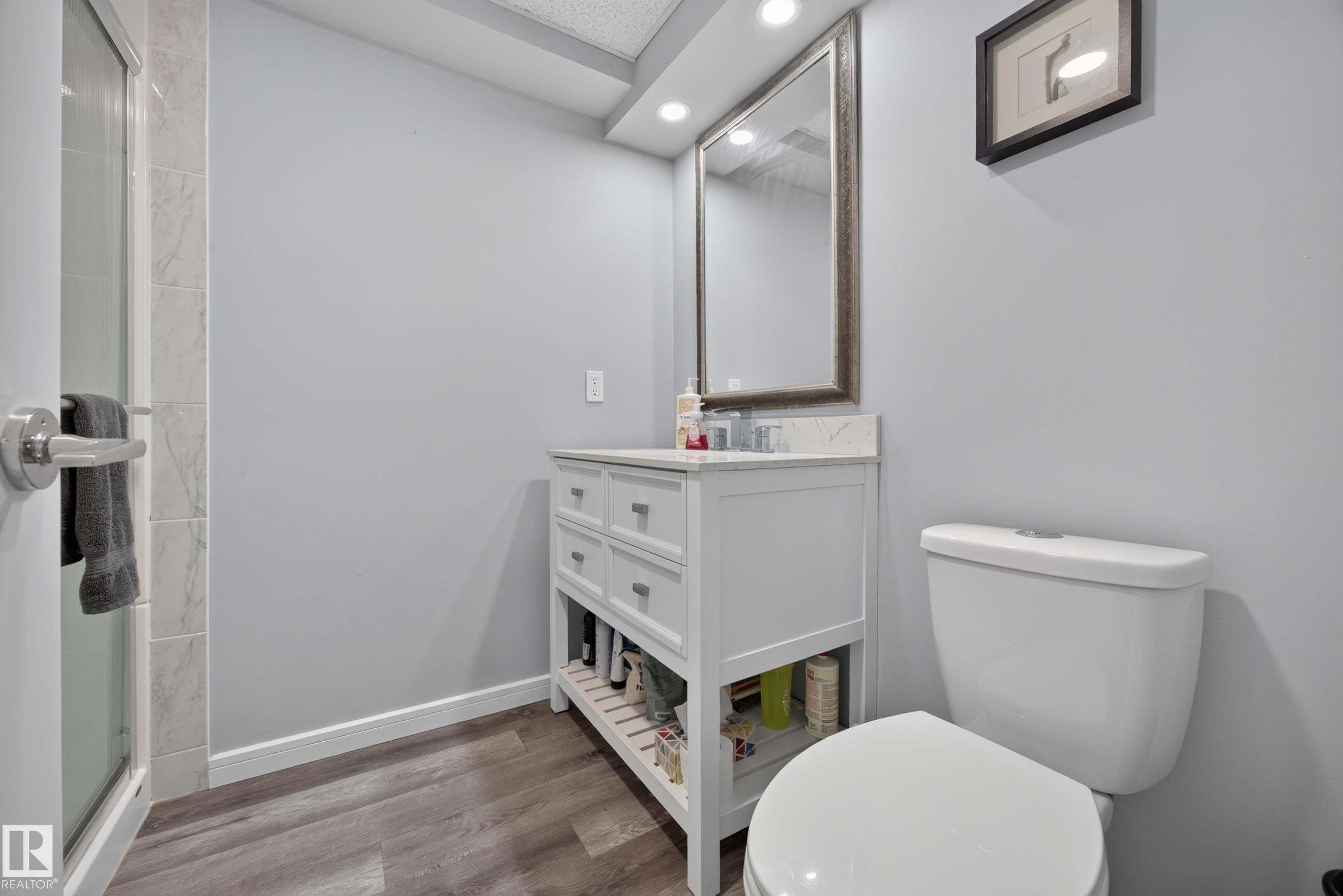 White vanity with a stone countertop, framed mirror, and recessed lighting - 156 Clareview Road Nw, Edmonton, AB - Indoor Photo Showing Bathroom