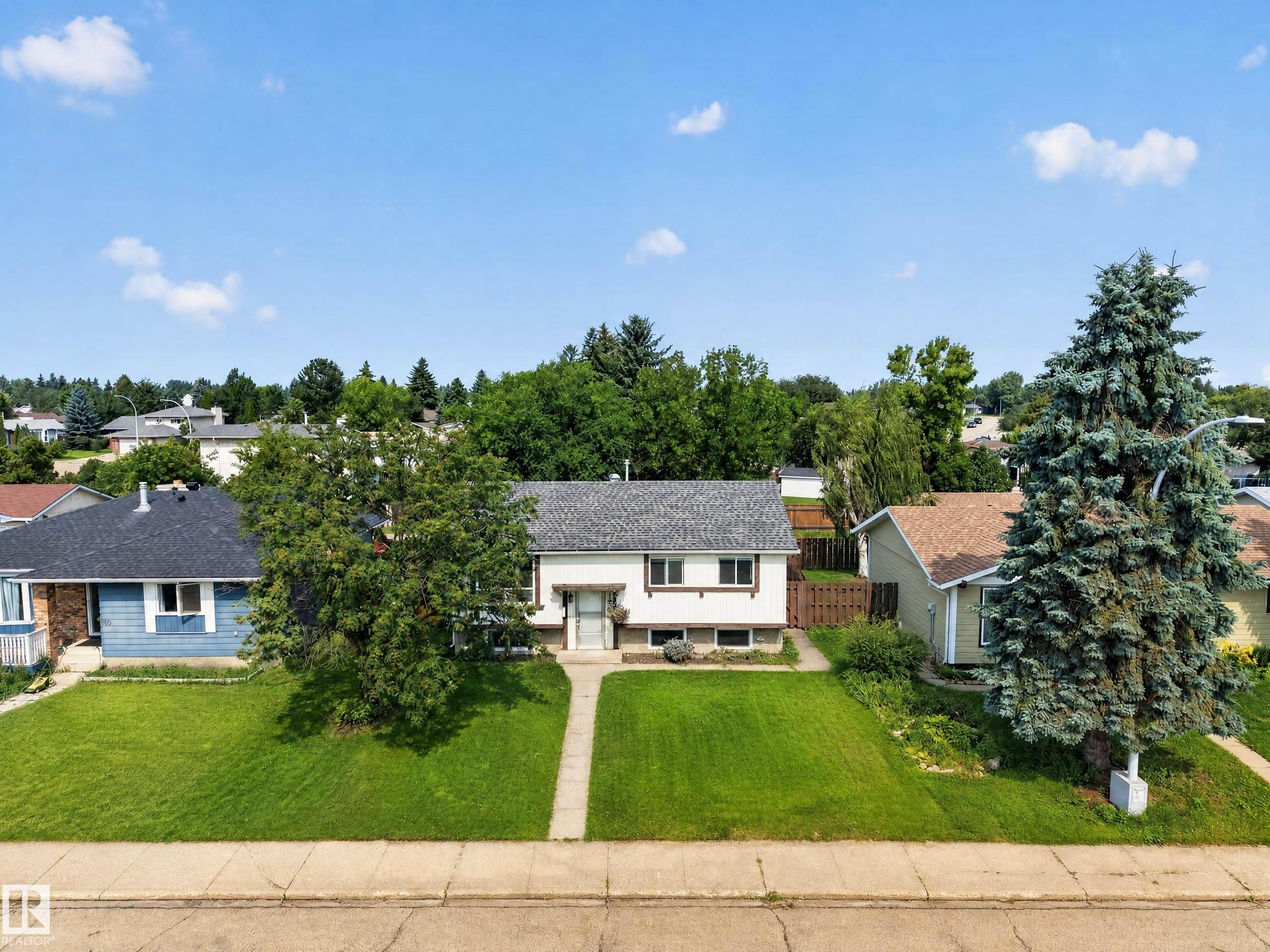 Single-story residence featuring a gray shingle roof, white exterior siding, and a concrete pathway leading to the front entry - 156 Clareview Road Nw, Edmonton, AB - Outdoor