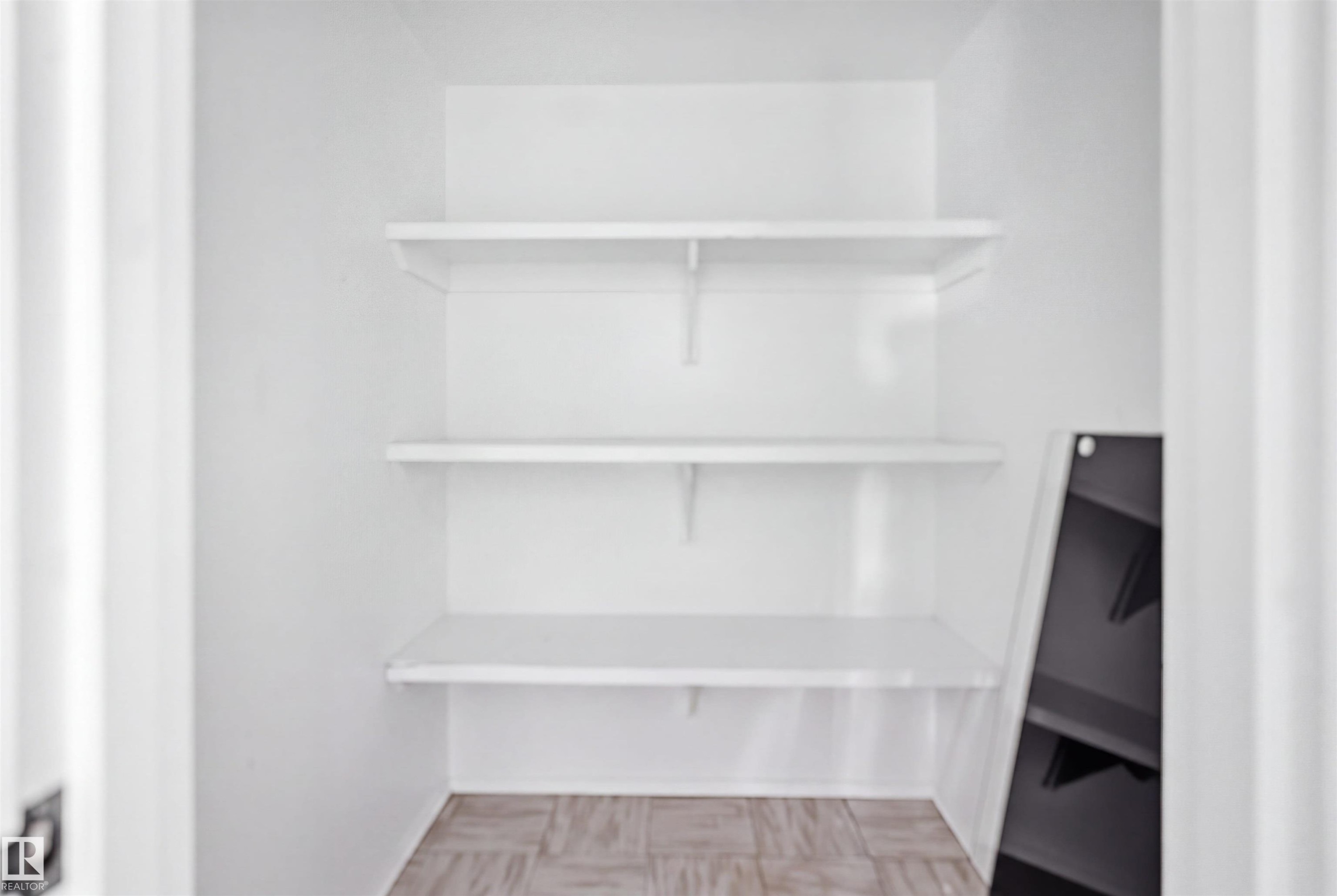 White shelving system with three levels, light-toned patterned flooring - 7825 159 Street Nw, Edmonton, AB - Indoor With Storage