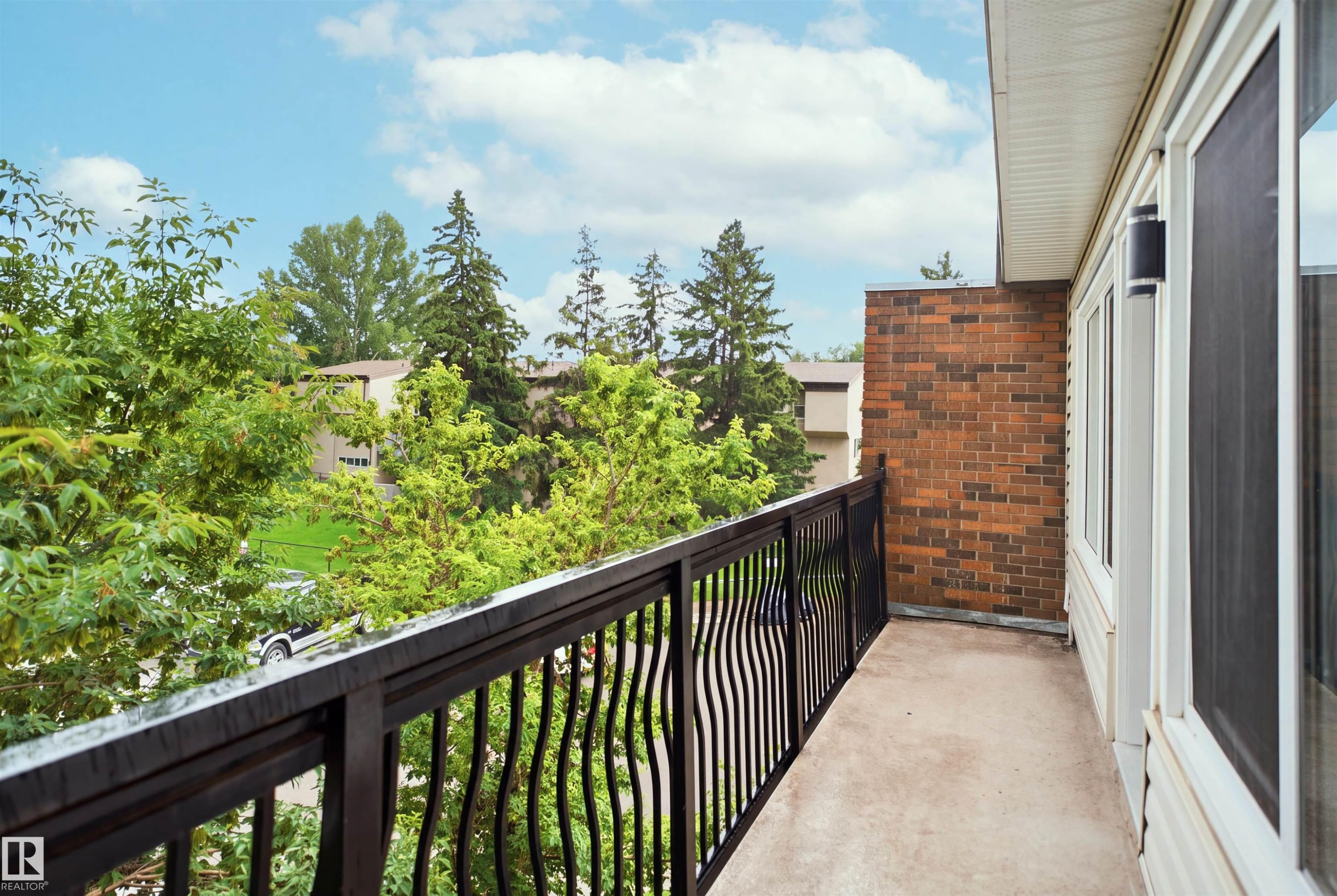 Balcony with a black metal railing, concrete flooring, and an exterior brick wall - 7825 159 Street Nw, Edmonton, AB - Outdoor With Balcony With Exterior