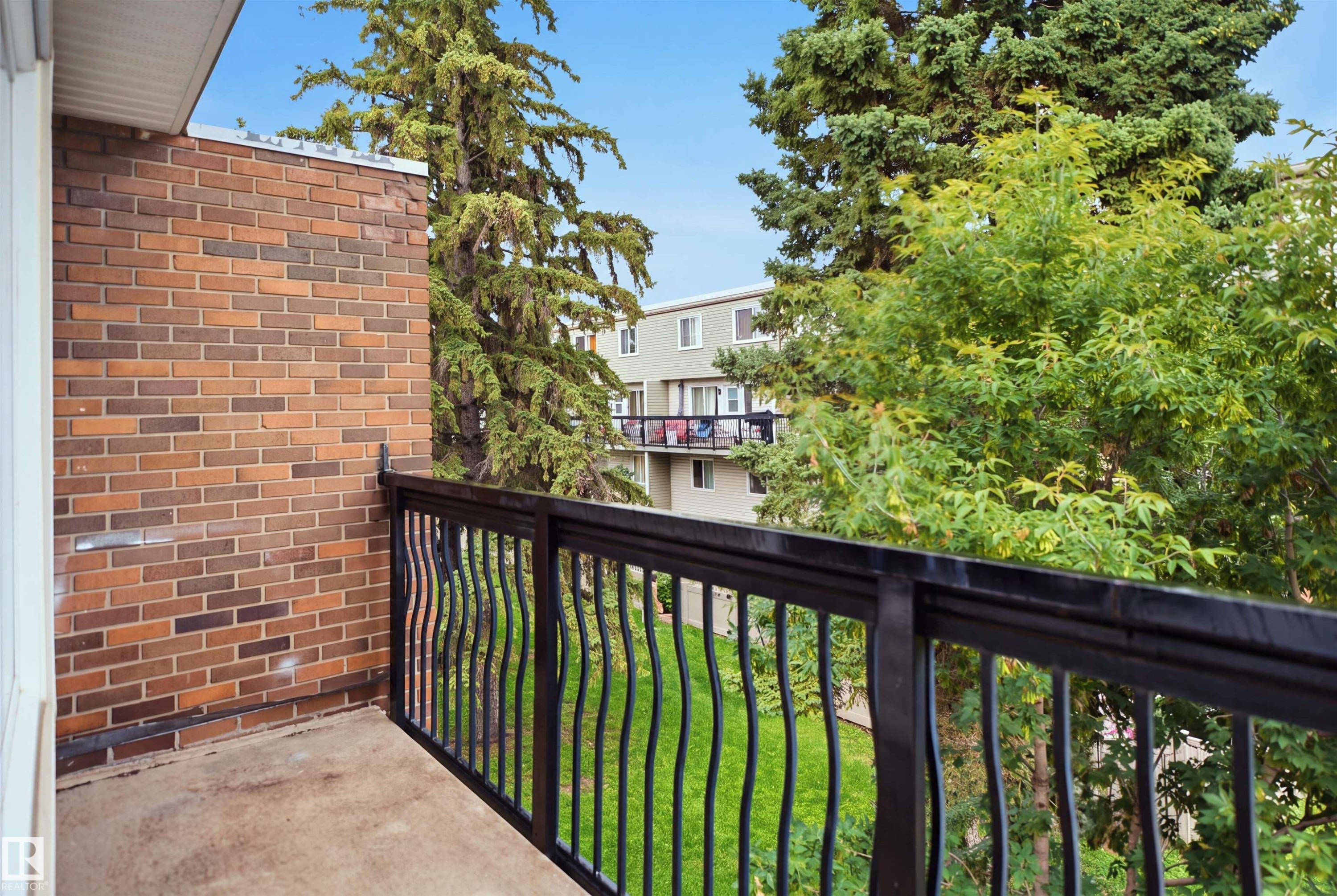 Exterior balcony with a black metal railing and brick wall - 7825 159 Street Nw, Edmonton, AB - Outdoor With Balcony With Exterior