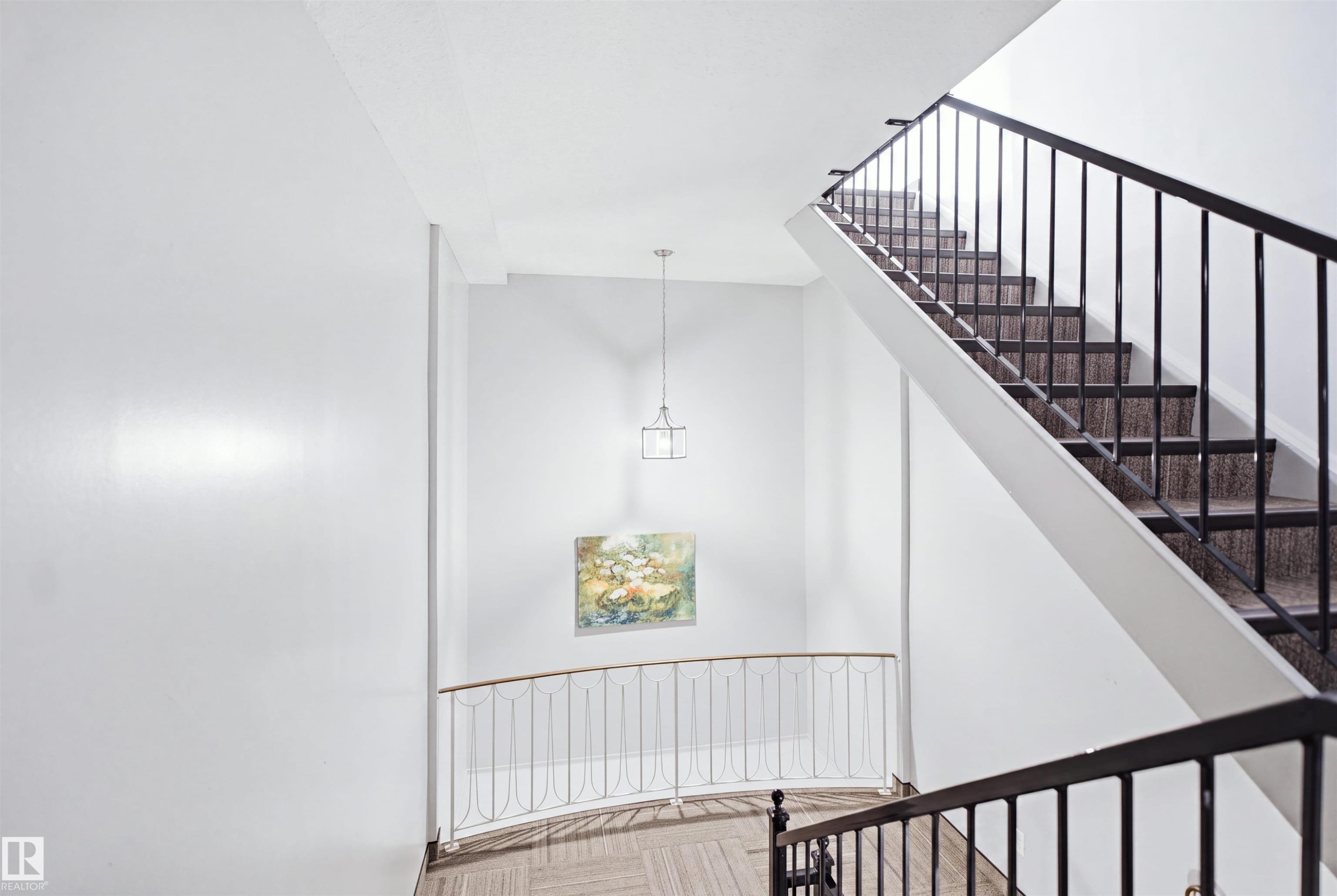 Stairwell featuring metal railings, pendant lighting, and carpeted stairs - 7825 159 Street Nw, Edmonton, AB - Indoor Photo Showing Other Room