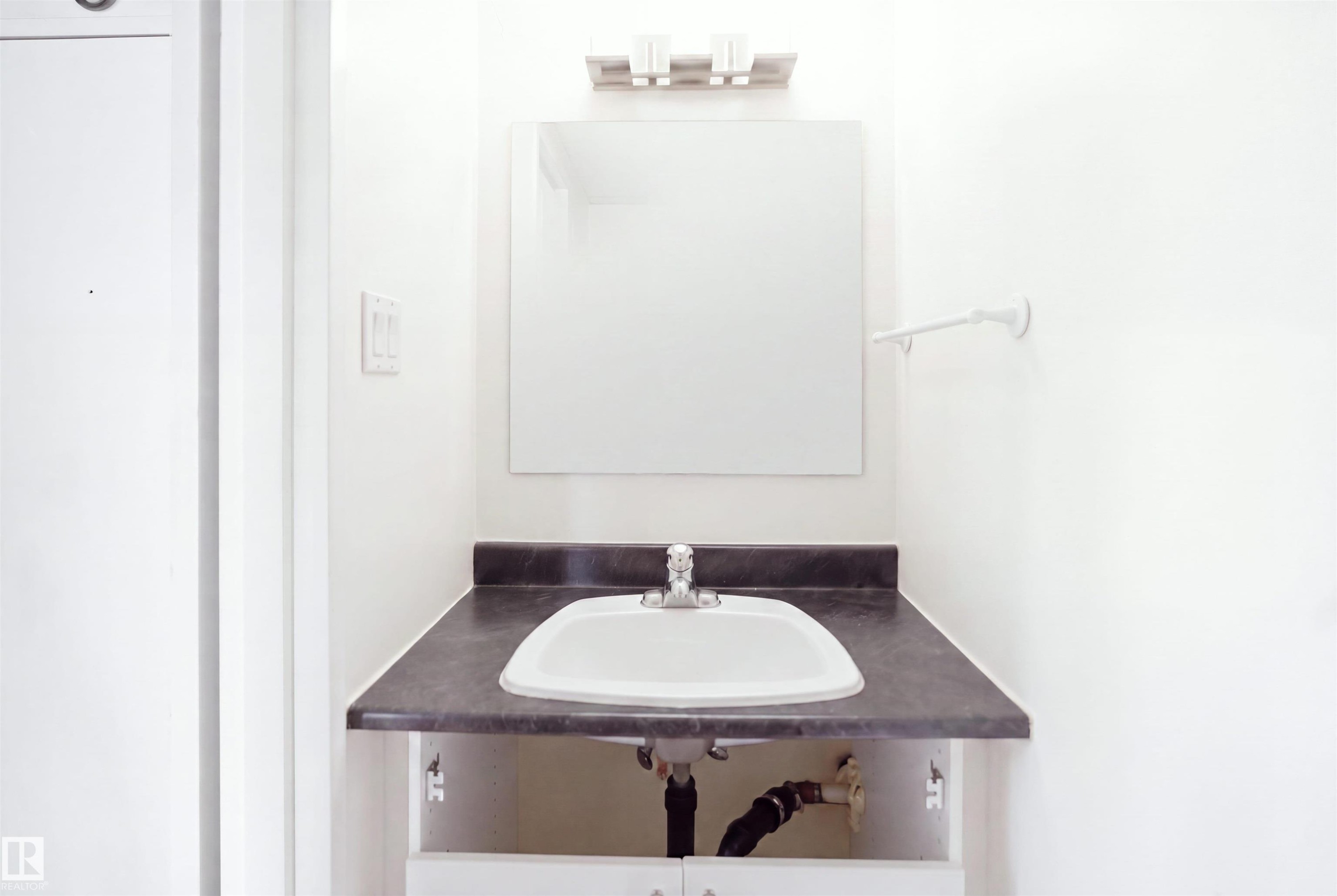 Countertop vanity with an integrated sink and chrome faucet - 7825 159 Street Nw, Edmonton, AB - Indoor Photo Showing Bathroom