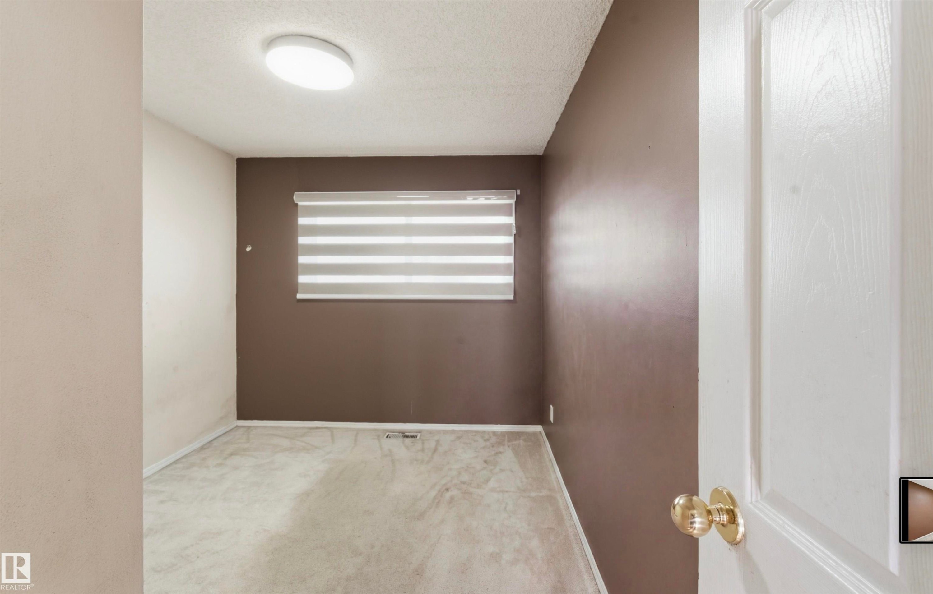 Recessed ceiling light fixture and window with horizontal blinds - 13604 90A Street Nw, Edmonton, AB - Indoor Photo Showing Other Room