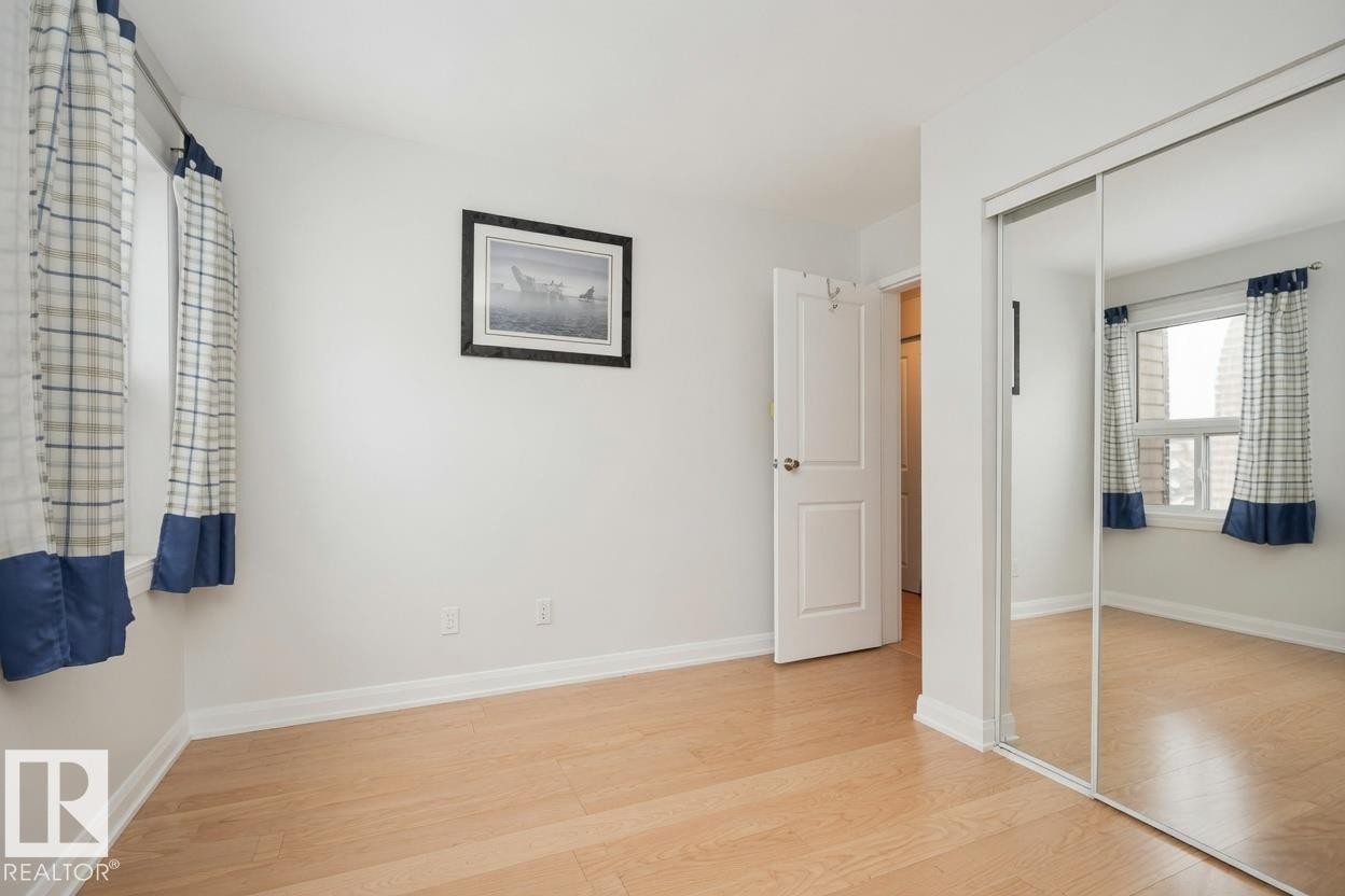 Light wood-finish flooring, white walls, and a mirrored sliding closet door - #31 11255 31 Av Nw, Edmonton, AB - Indoor Photo Showing Other Room