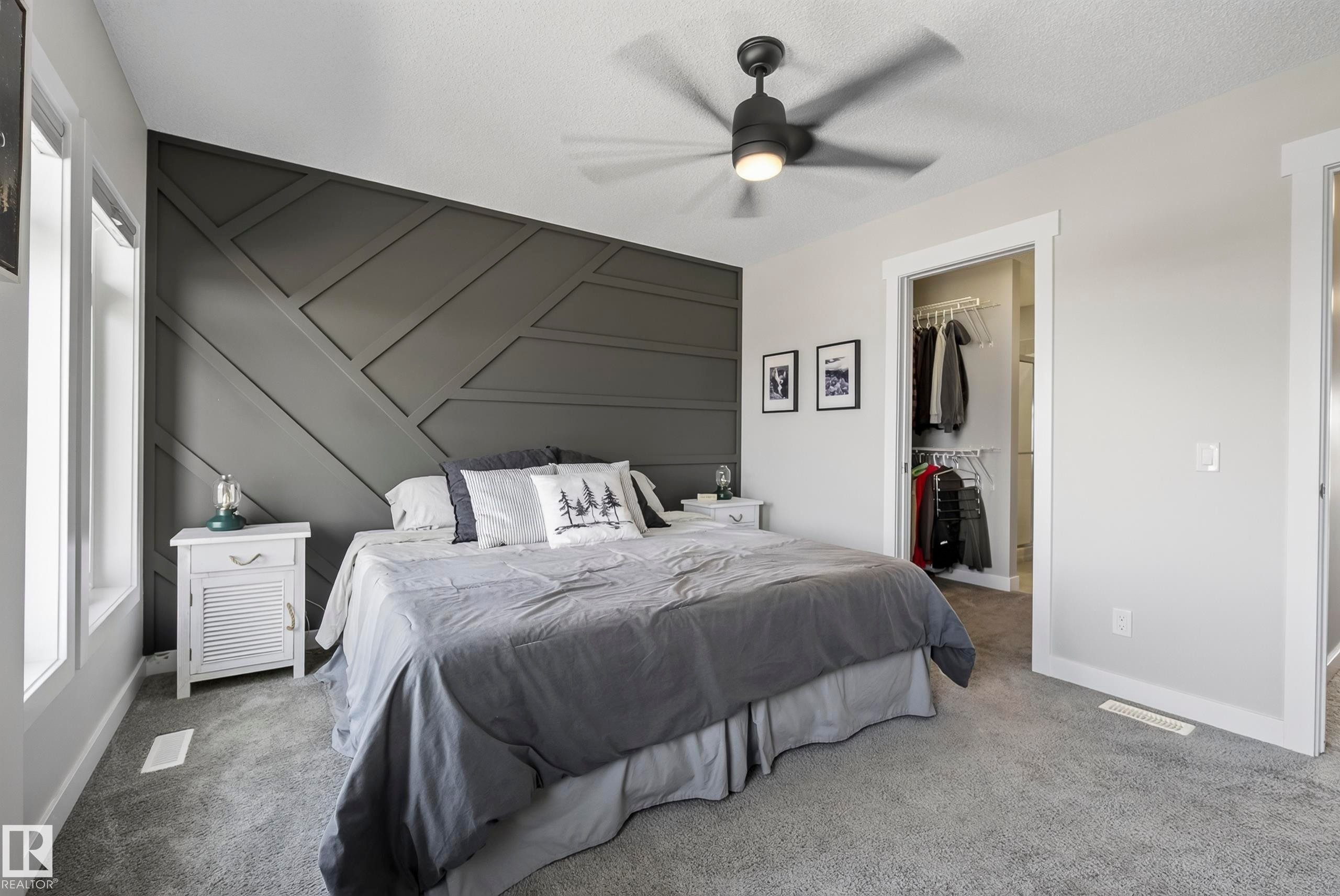 Accent wall with geometric paneling, ceiling fan with integrated lighting, carpeted flooring, and built-in closet with shelving - 45 Joyal Way, St. Albert, AB - Indoor Photo Showing Bedroom