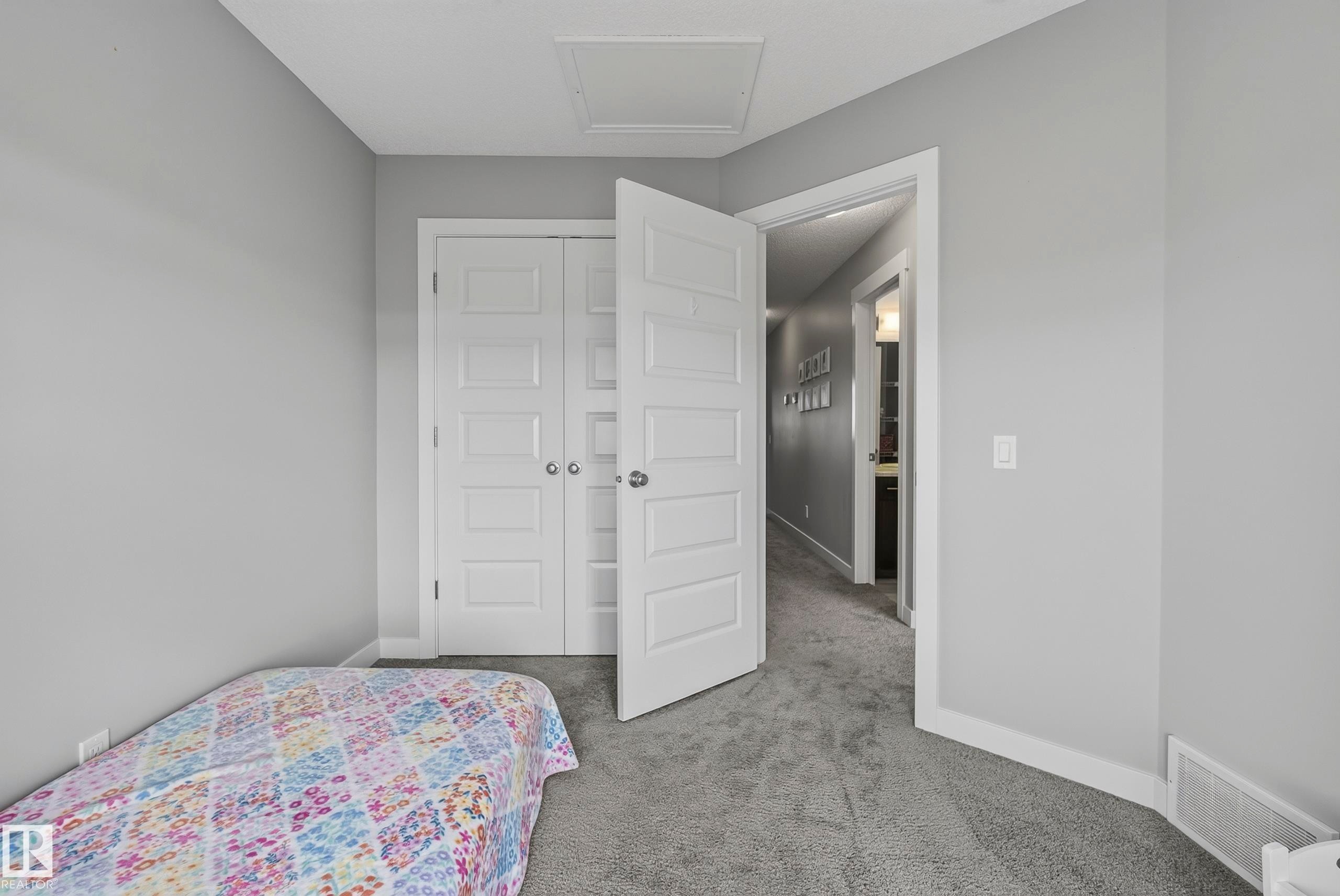 Light gray wall paint, gray carpet flooring, white paneled doors, white trim, and a white ceiling access panel - 45 Joyal Way, St. Albert, AB - Indoor Photo Showing Bedroom