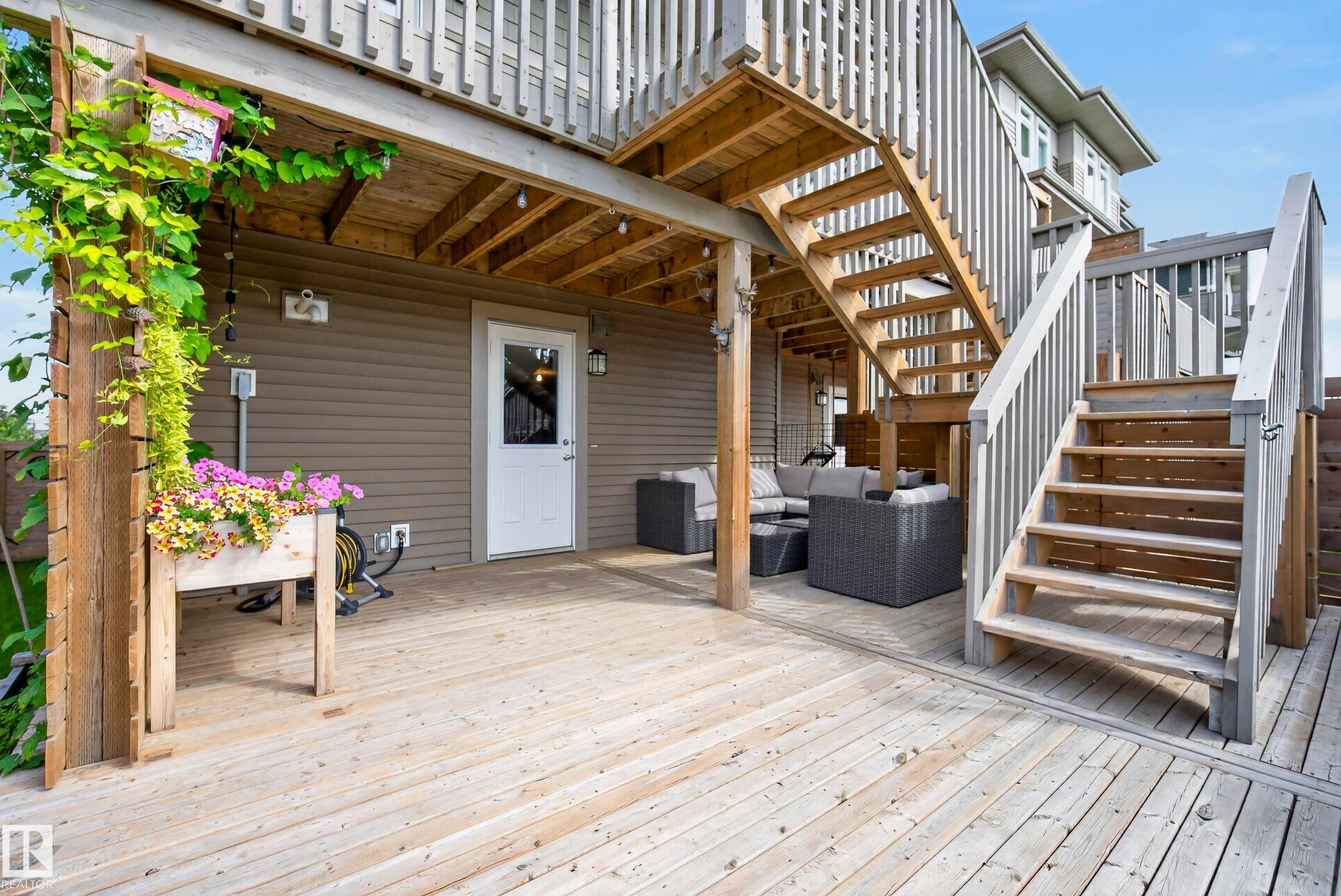 Expansive wood-finish deck with multiple levels and a white exterior door - 45 Joyal Way, St. Albert, AB - Outdoor With Deck Patio Veranda With Exterior