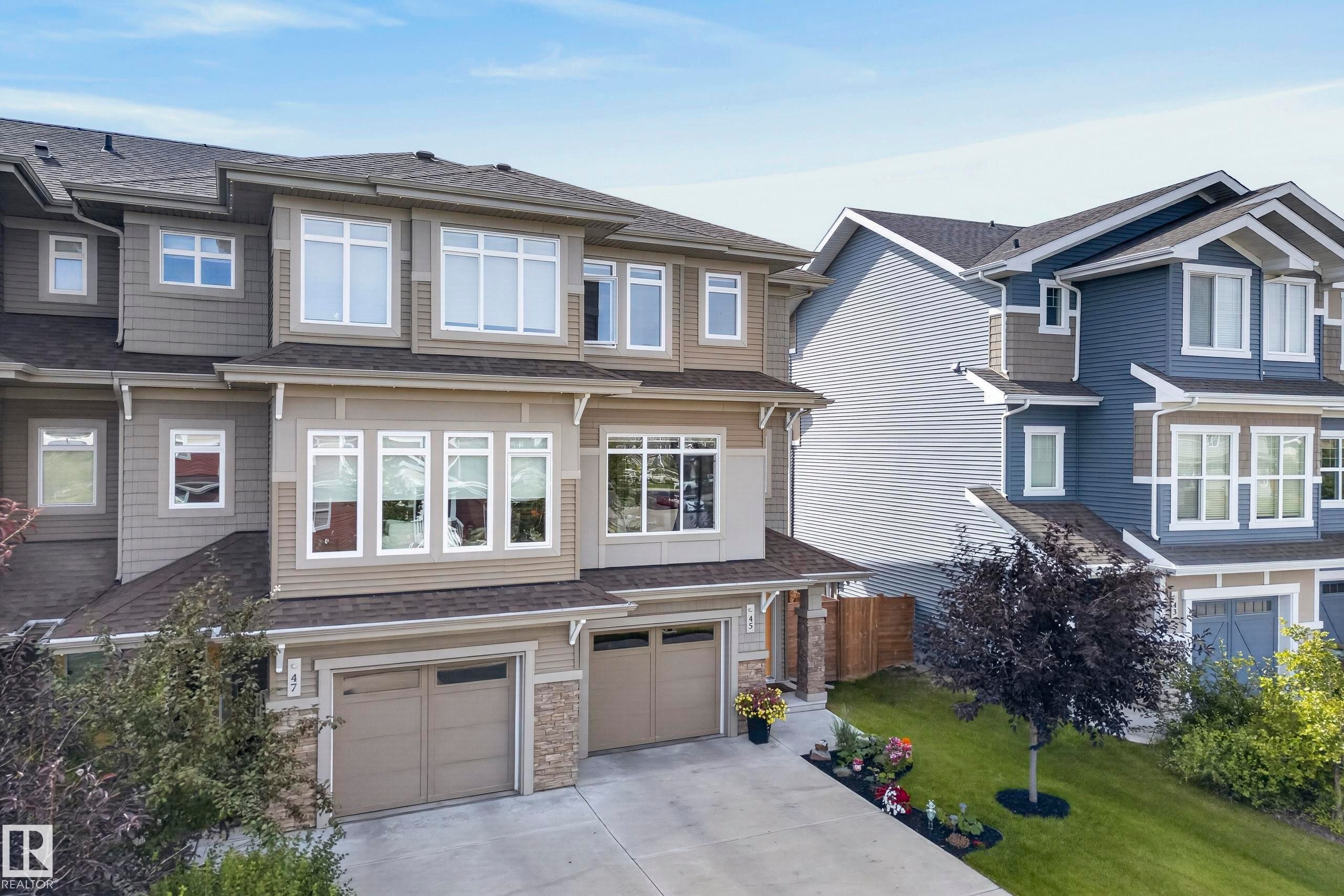 Multi-level exterior with varied siding, prominent windows, attached garage, and stone accents - 45 Joyal Way, St. Albert, AB - Outdoor With Facade