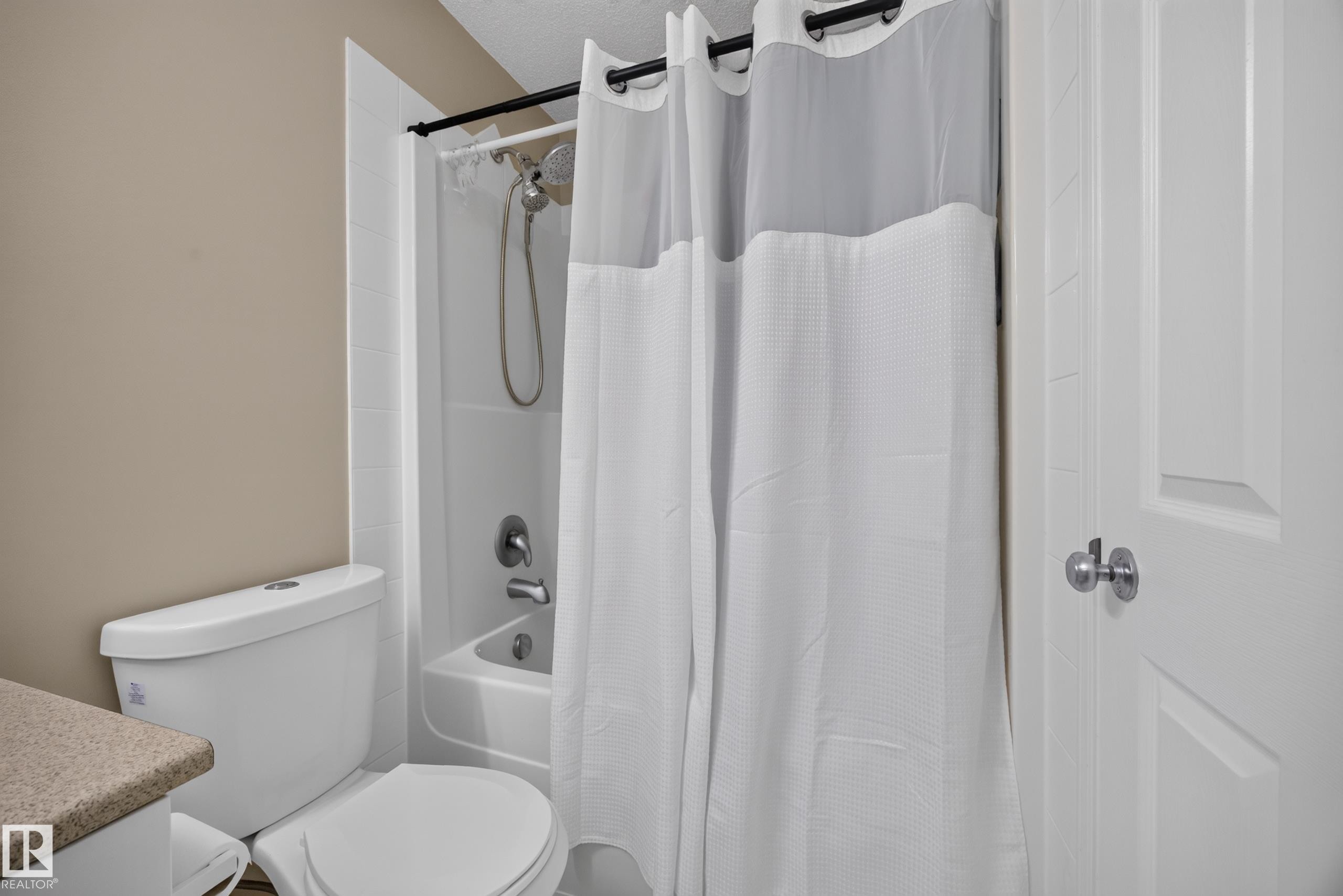 Full white shower-over-tub combination with chrome fixtures and showerhead - #7 155 Crocus Cr, Sherwood Park, AB - Indoor Photo Showing Bathroom